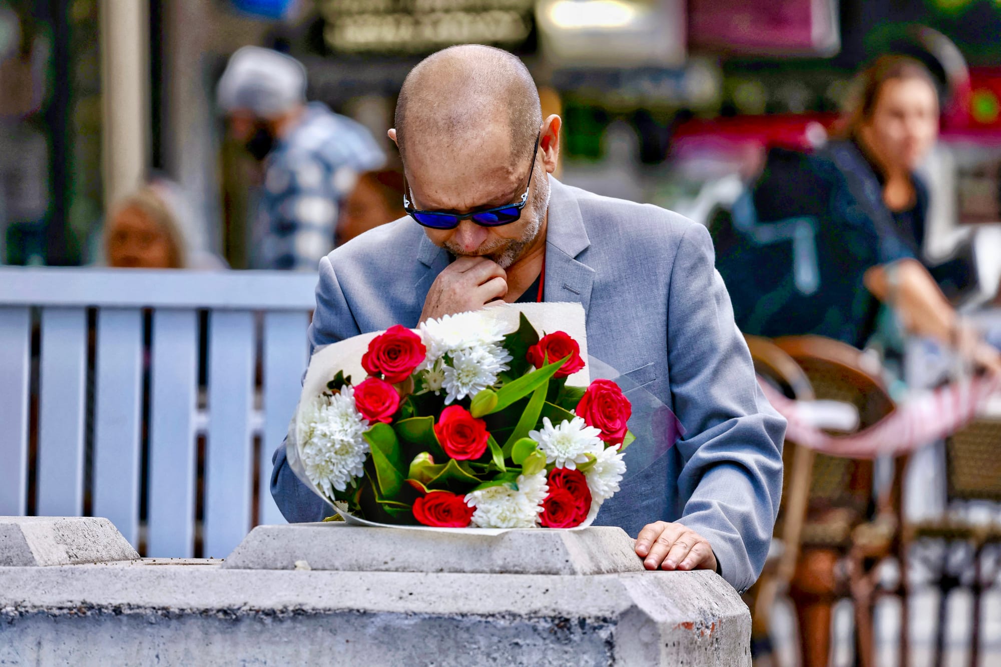 Man lays flowers as a tribute for victims of Sydney mall attack