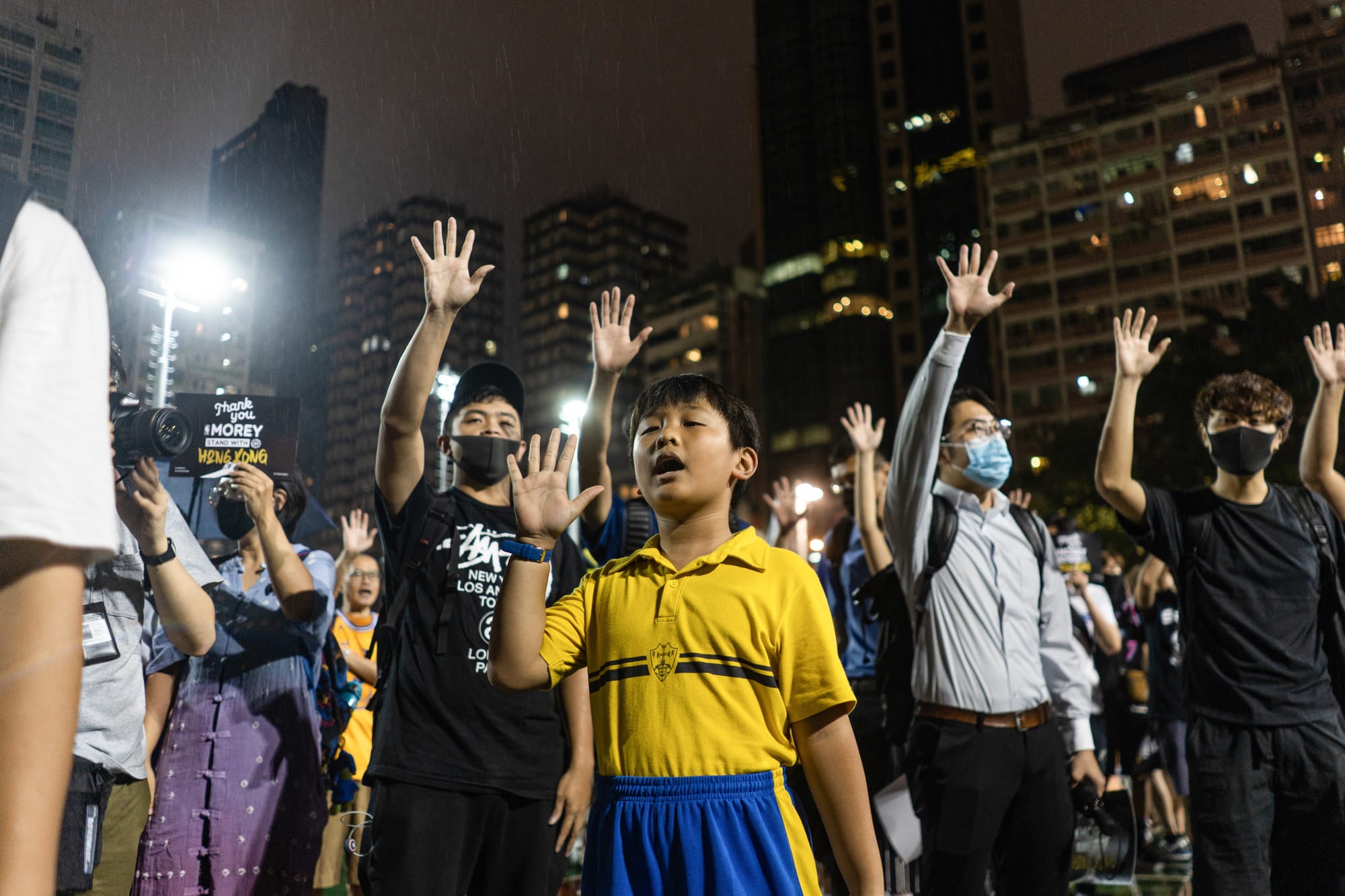 hong kong protester child singing glory hong kong anthem raised hands