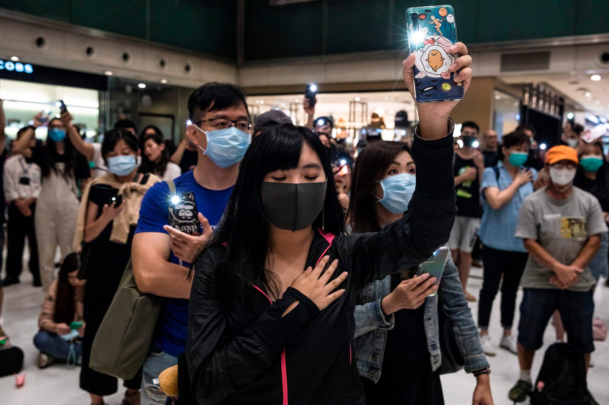 hong kong woman protest glory to hong kong anthem phone flashlight