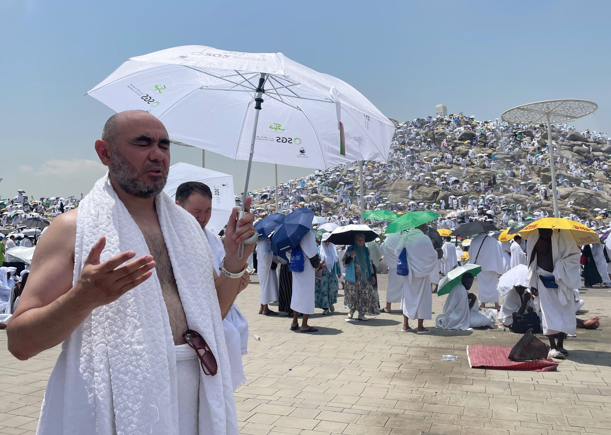 hajj muslim pray umbrella hot heat 2024
