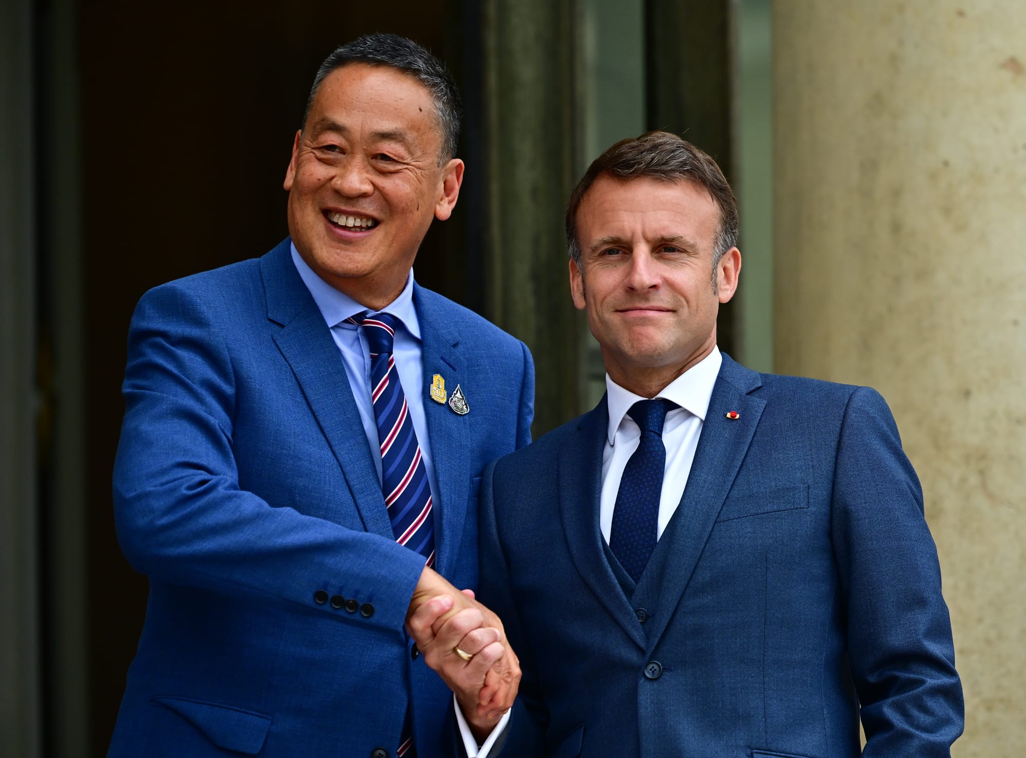 President Emmanuel Macron (R) welcomes Prime Minister of Thailand Srettha Thavisin