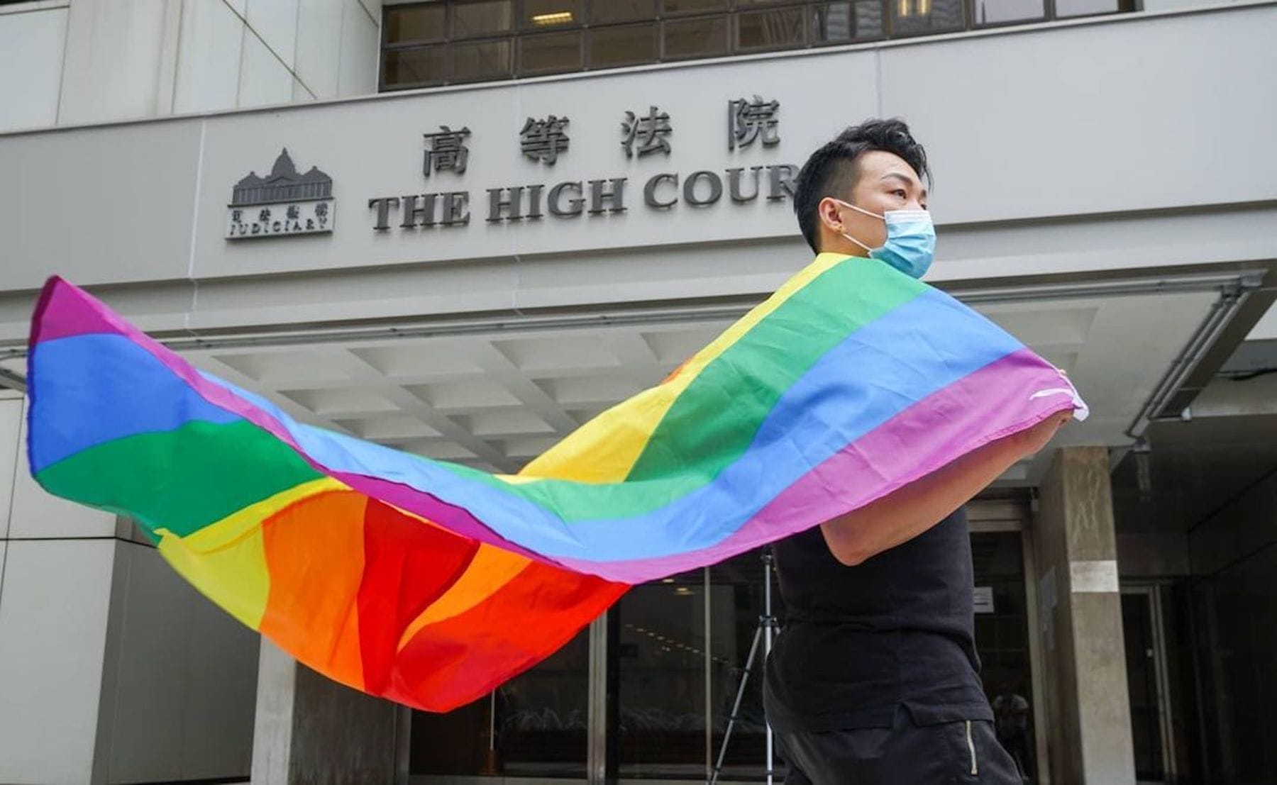 Person holds pride flag in front of Hong Kong's high court building