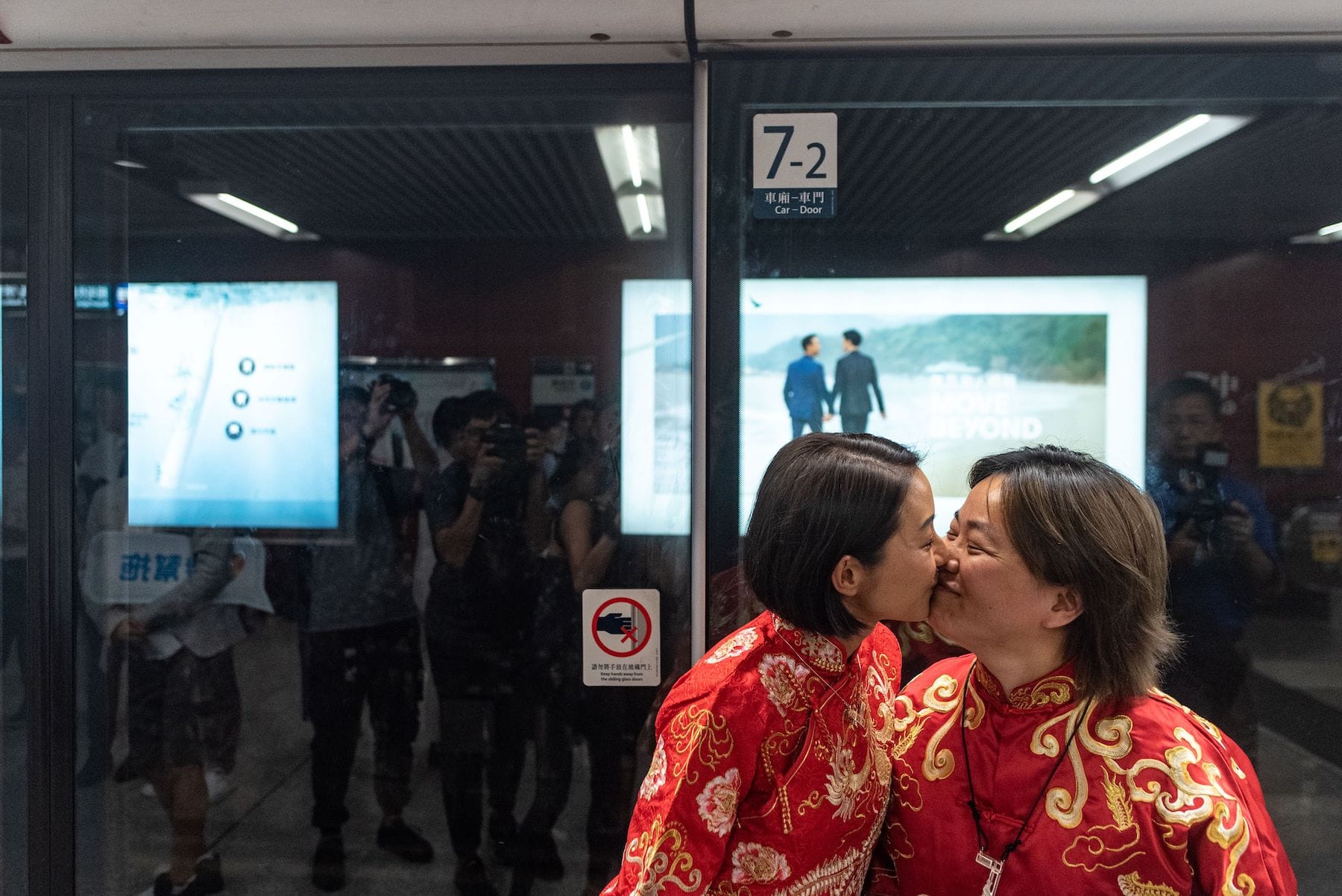 Lesbian couple wearing red gown kiss in Hong Kong