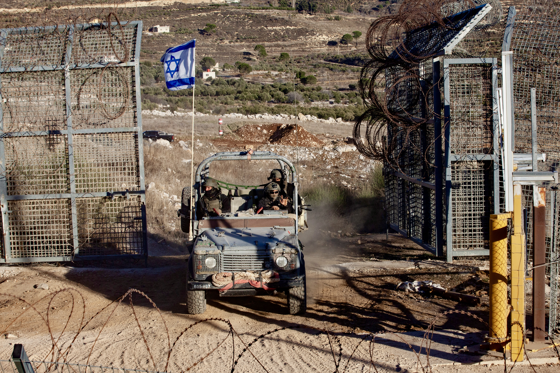 Israeli troops and military vehicles cross in and out of Syria through a gate in the boundary fence near the Druze village of Majdal Shams on the Israeli annexed Golan Heights