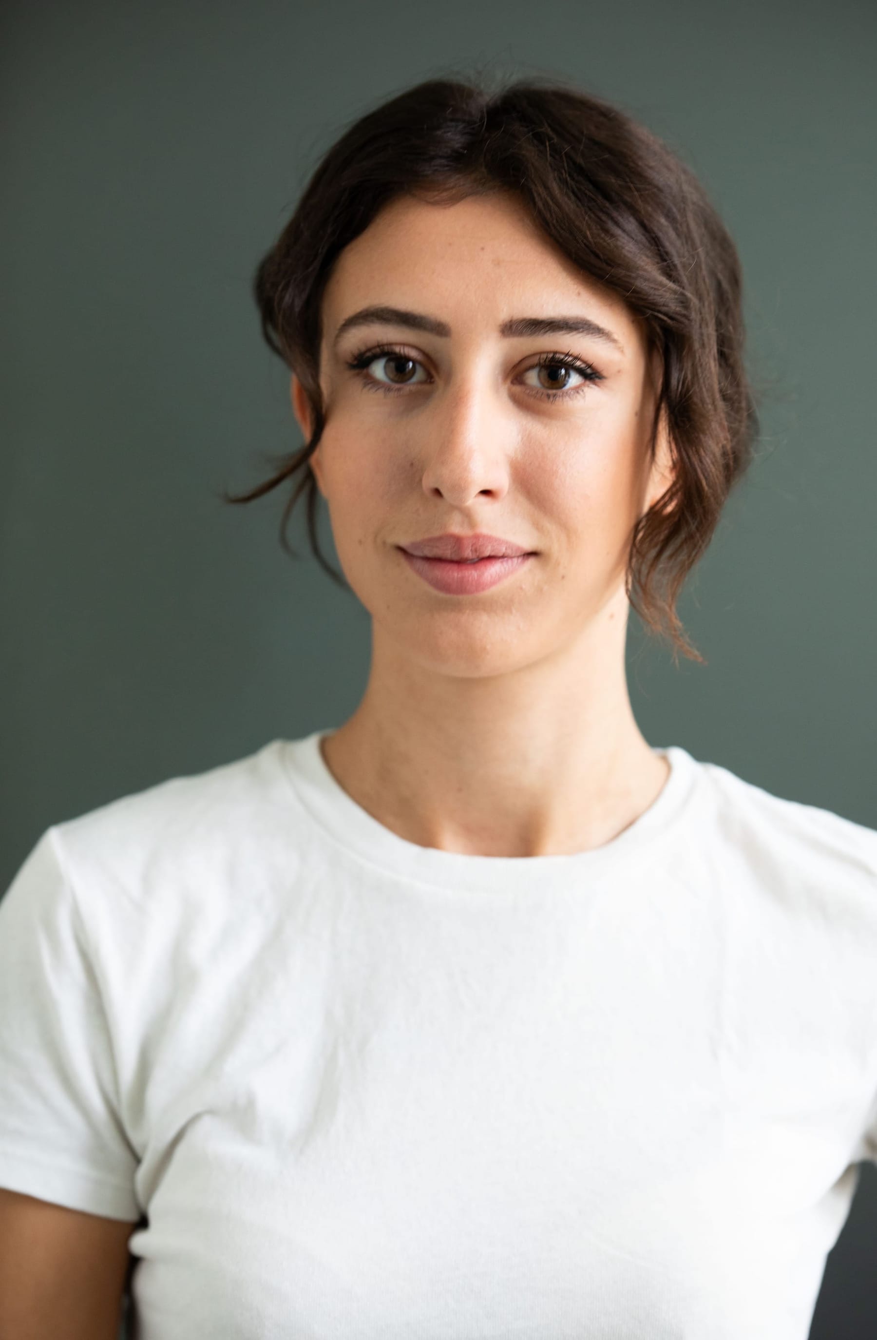 A clear portrait of Cecilia Sala in a plain white T-shirt. Sala was an Italian woman journalist born in 1995. She is the author and voice of Stories, Chora Media's daily podcast that tells stories from around the world.