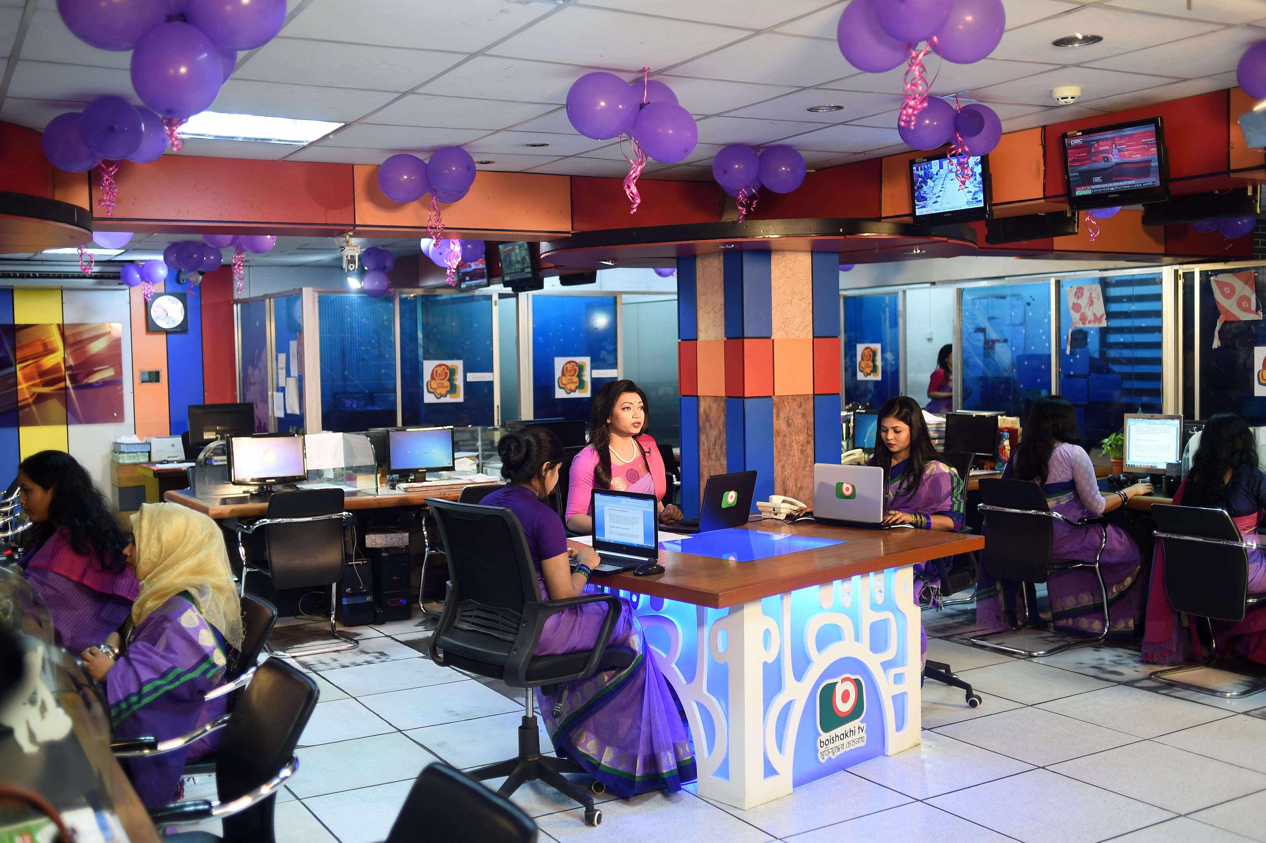 Tashnuva Anan Shishir (4L) presents the news on television at a news studio photo.