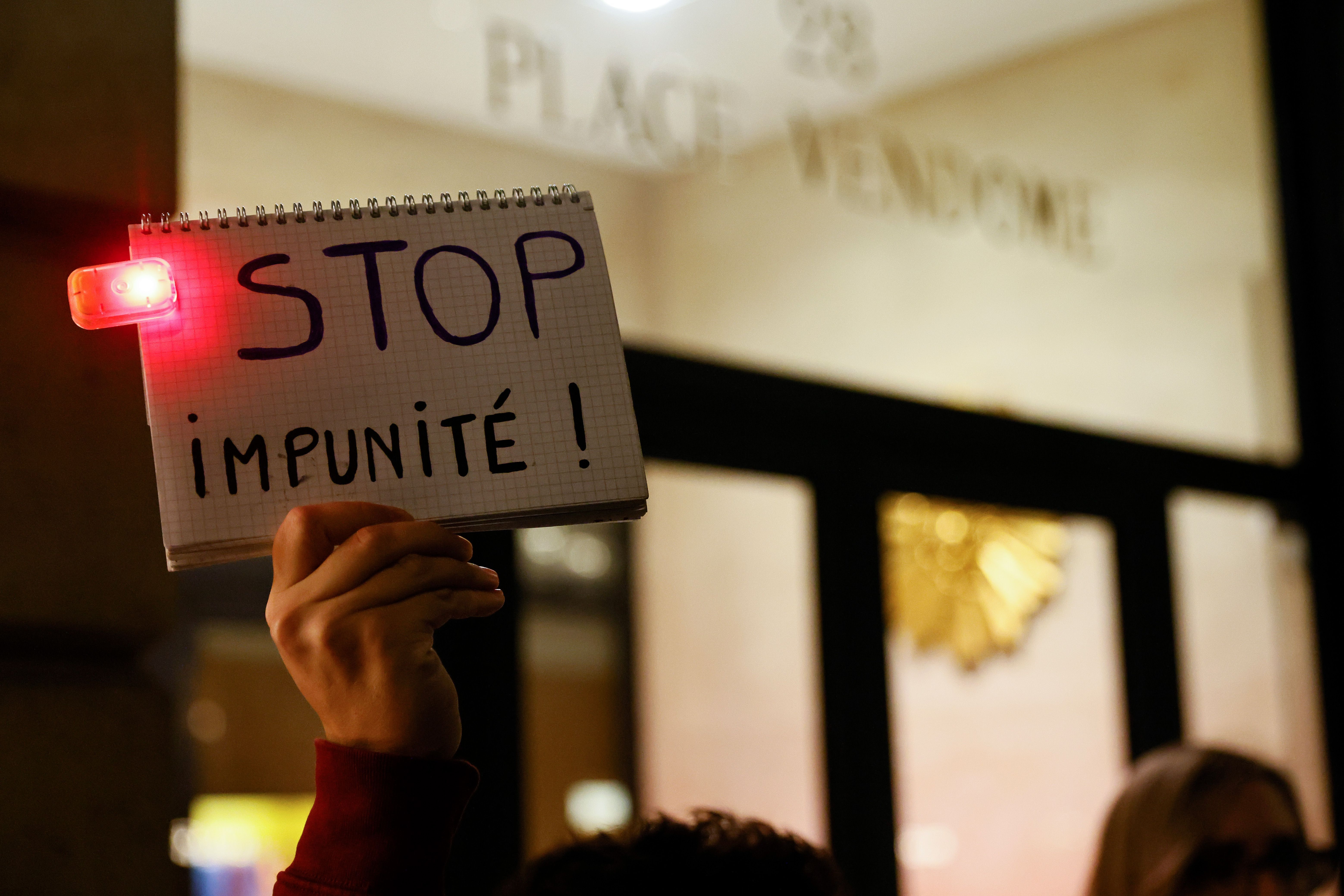 A Femen activist holds a sign reading "Stop impunity!" during a demonstration called by feminist groups after a French court retained the legal classification of "sexual infringement" photo.