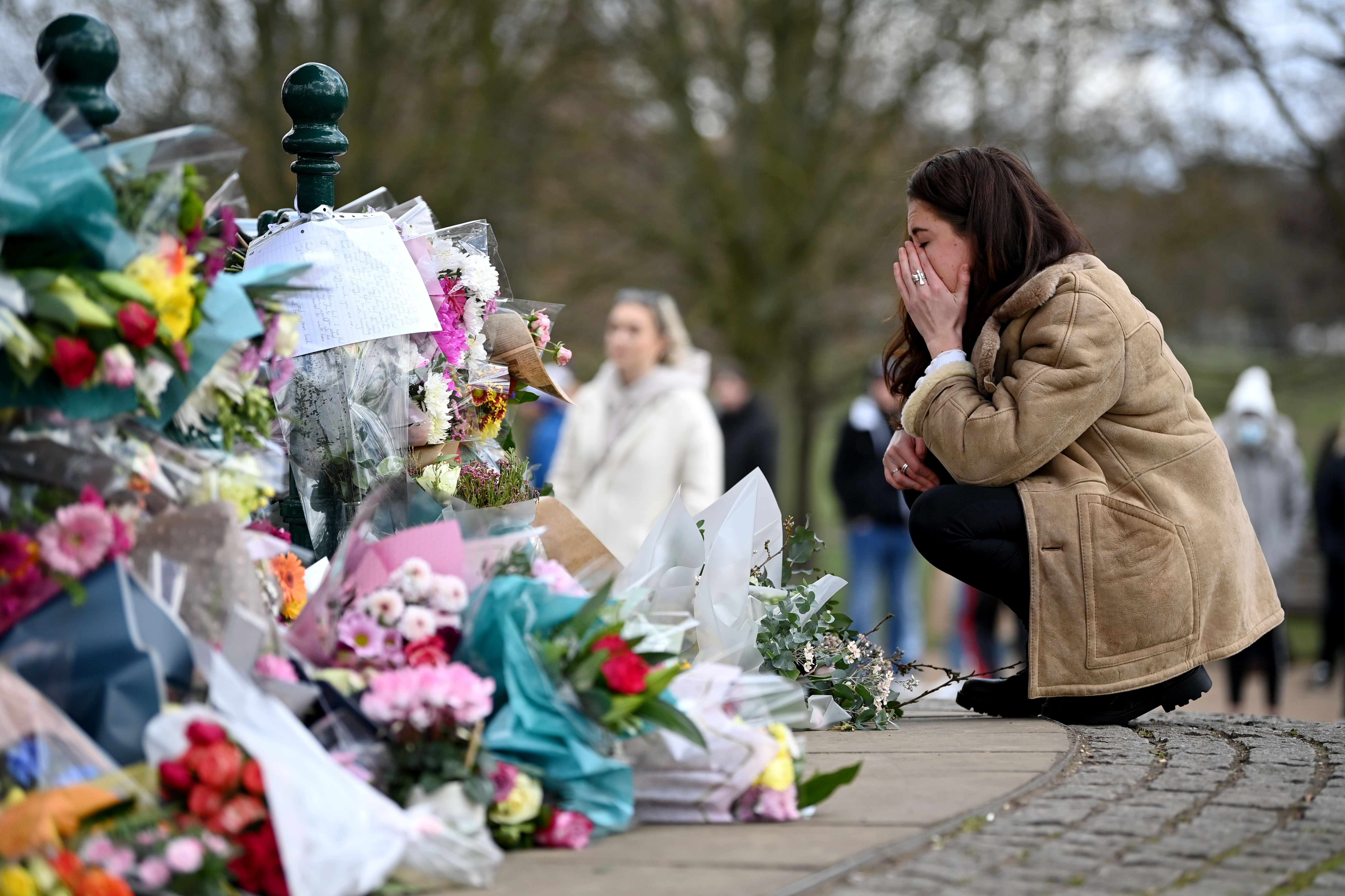 A woman reacts when she lays flowers in tribute to Sarah Everard photo. 