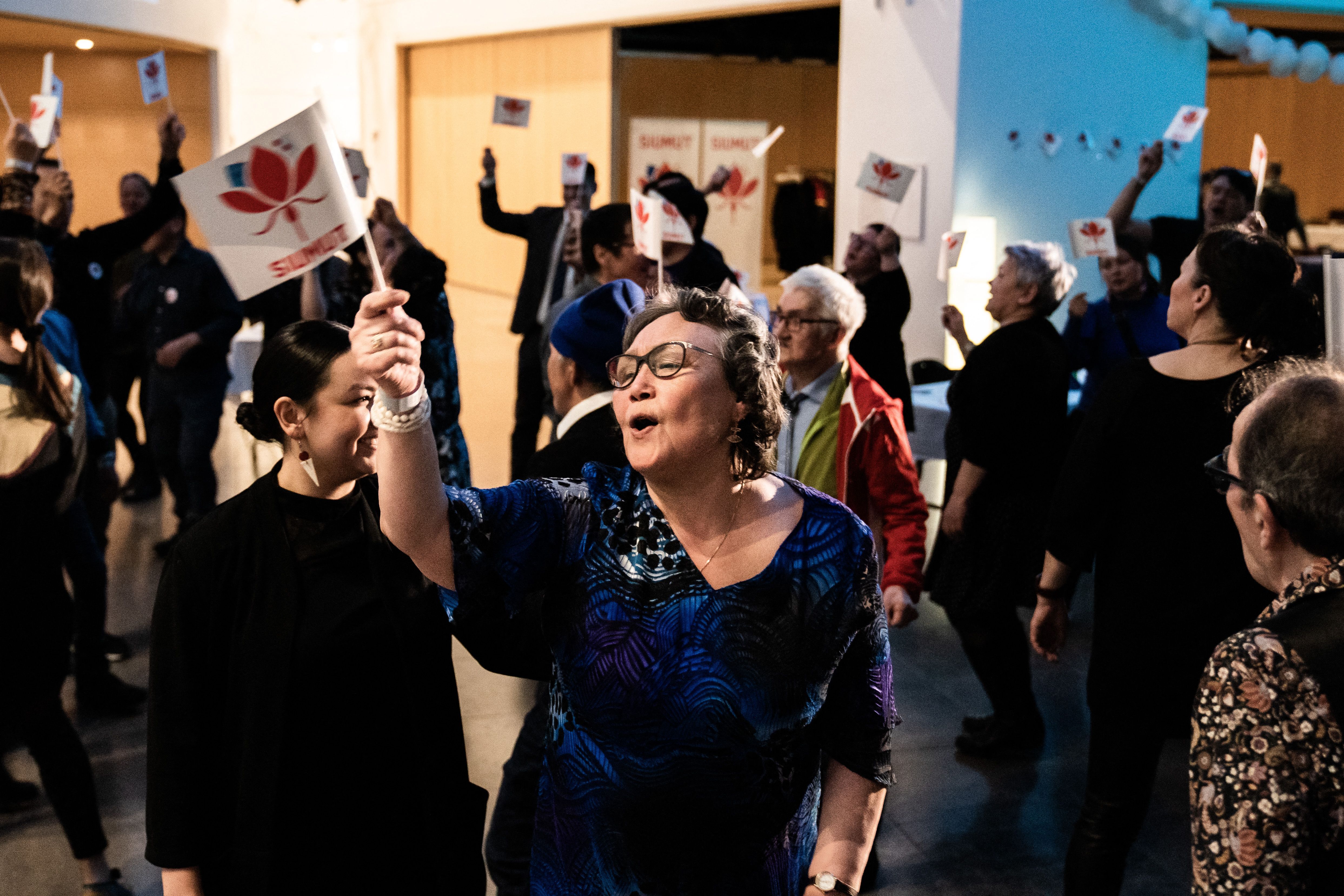 Members of the Siumut party wave party flags as they celebrate following the exit polls results of the legislative election in Nuuk photo.