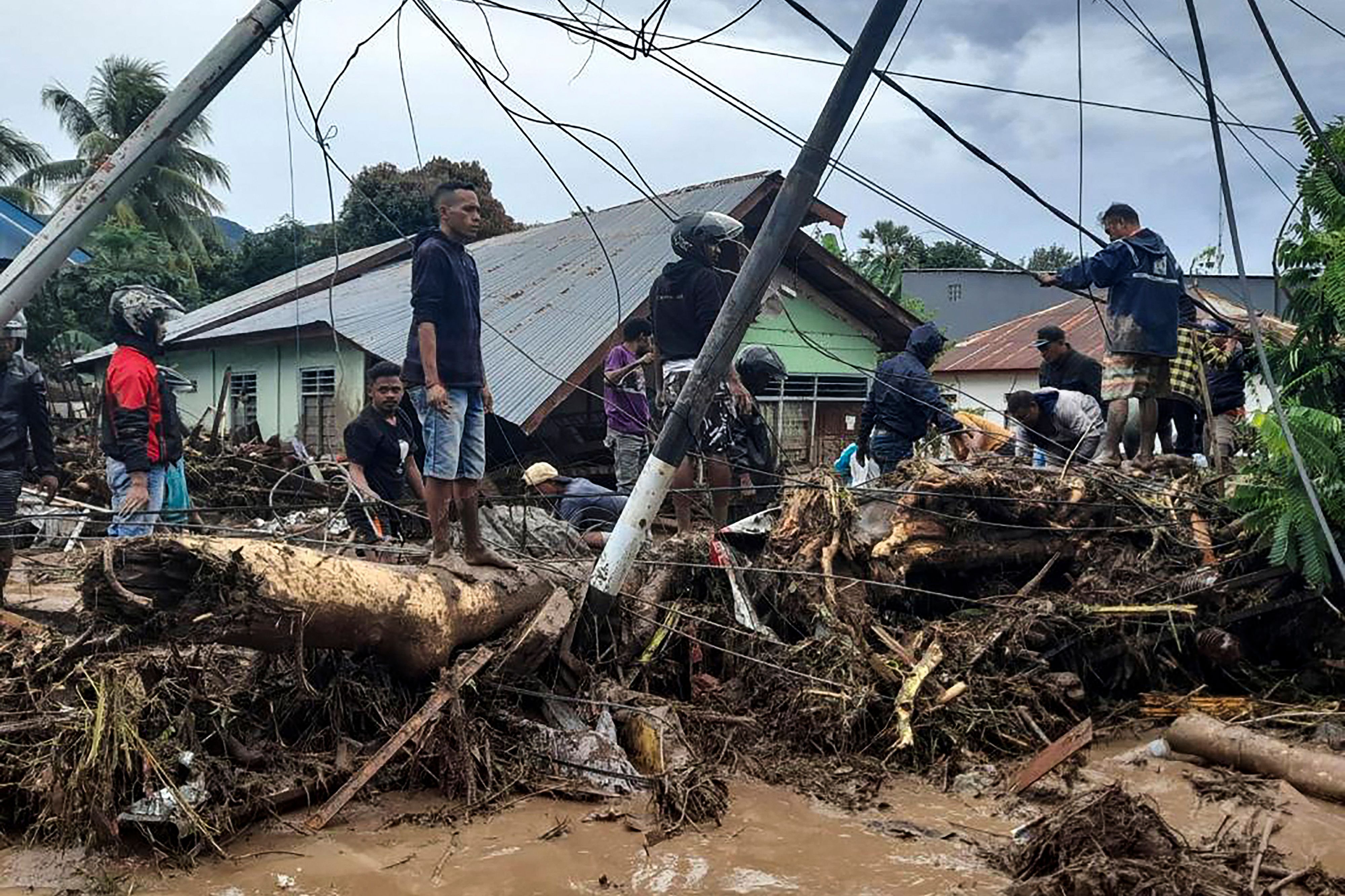 Residents check through debris near damaged homes in Waiwerang village of East Flores following torrential rains from Tropical Cyclone Seroja photo.