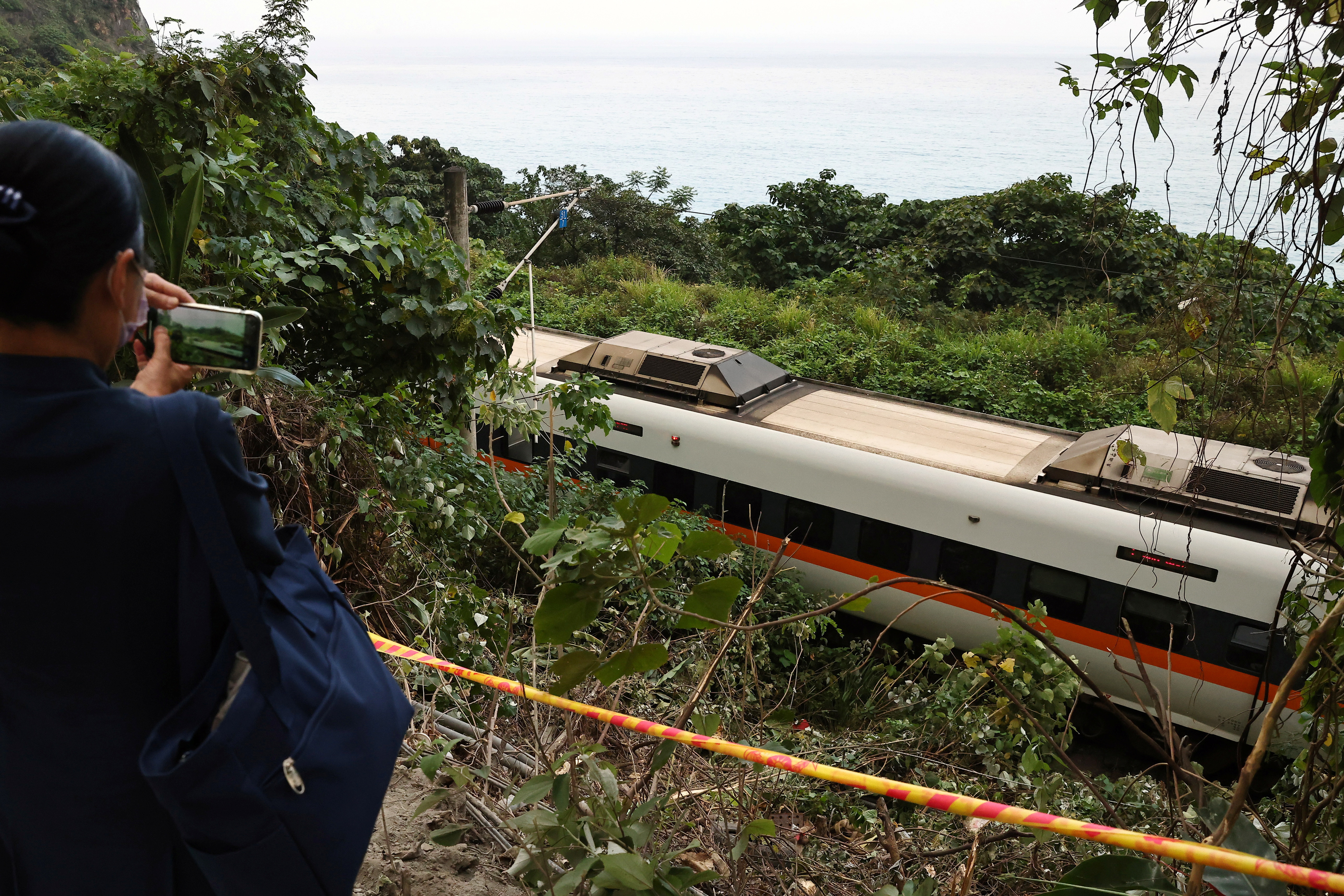 A cordon is seen in front of the train that derailed in a tunnel north of Hualien photo.