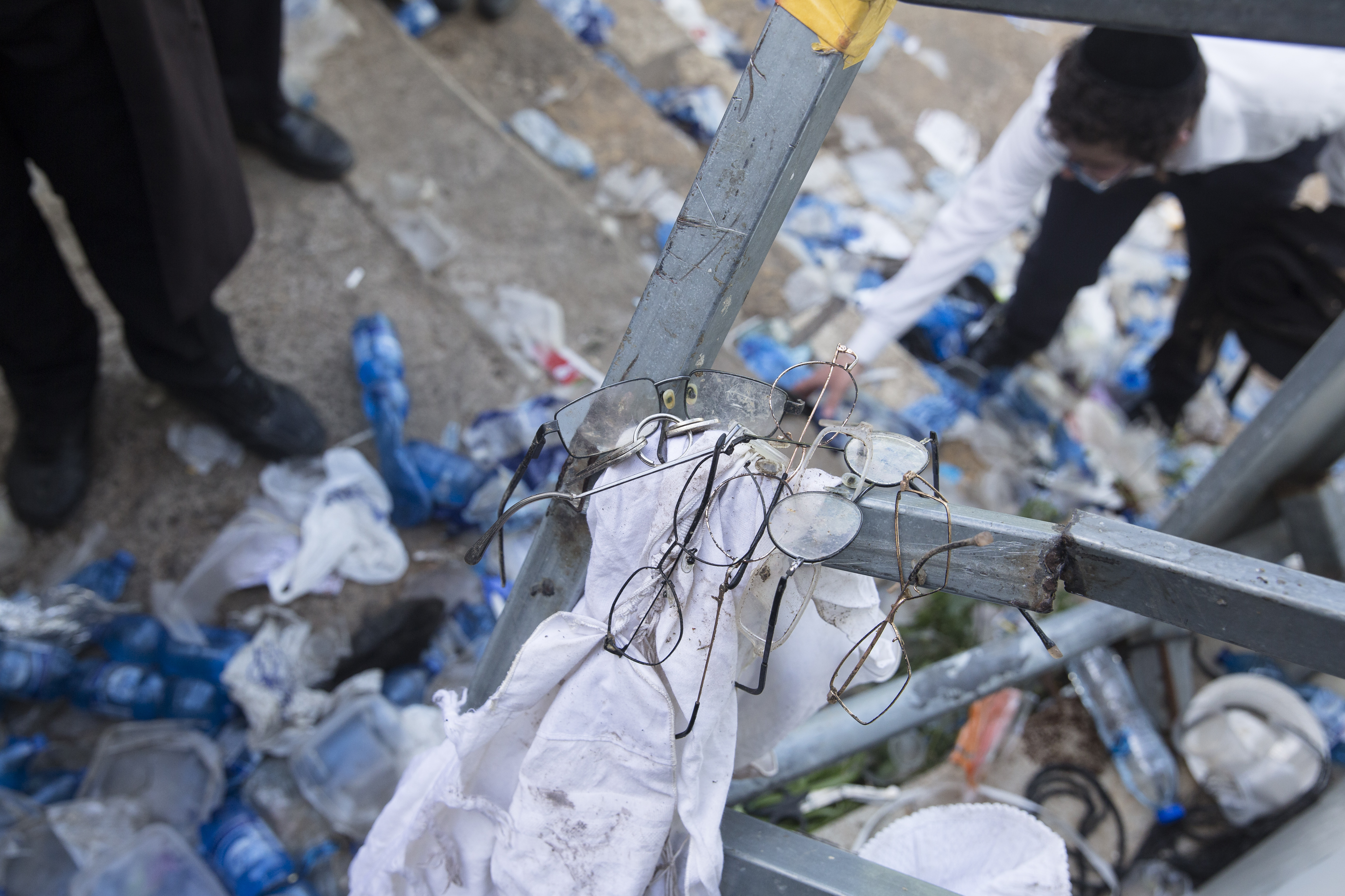 Glasses of Orthodox Jews left on a side walk as Orthodox Jews search for items left on the floor after dozens were killed in crush at a religious festival in Mount Meron, Israel.