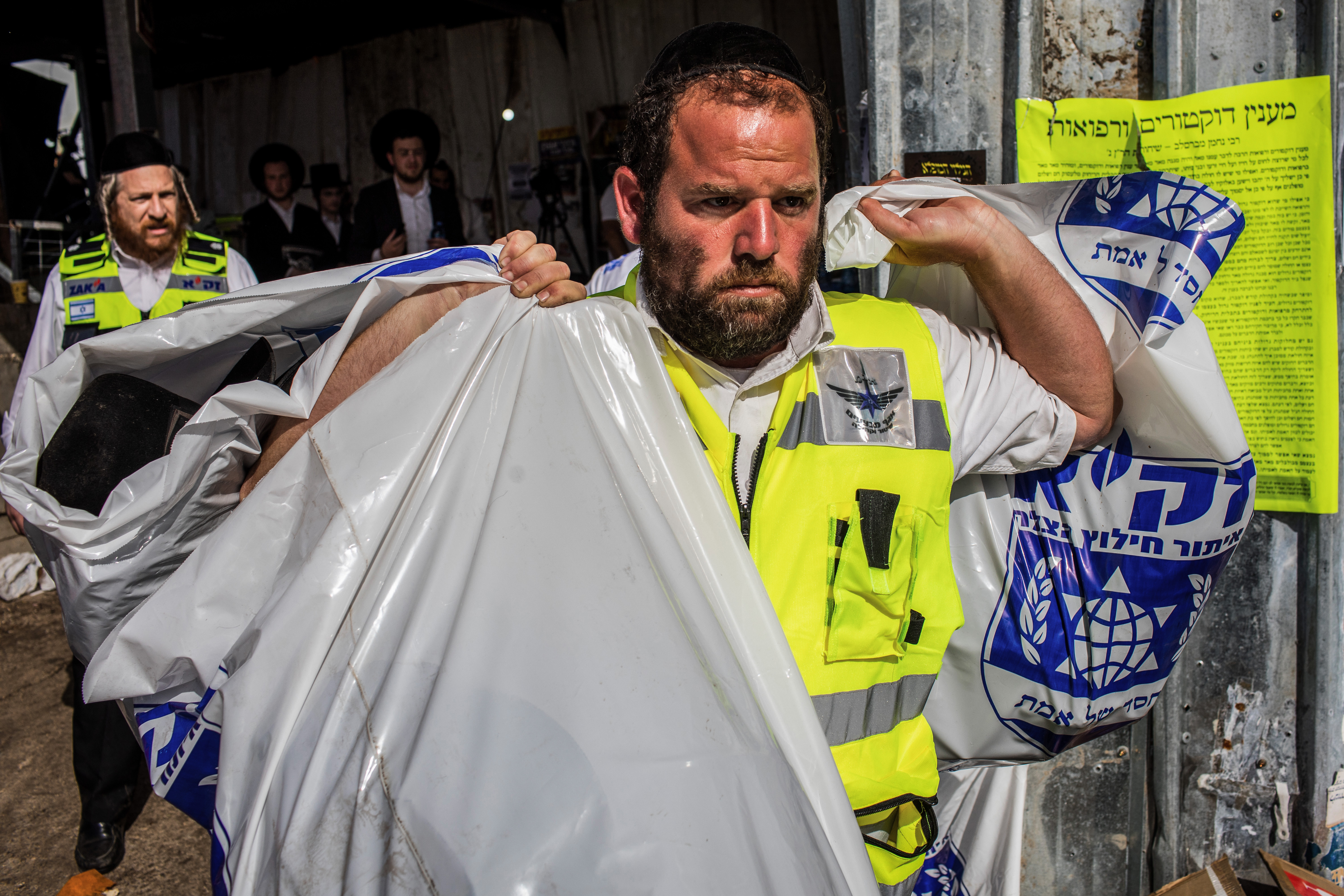 Israeli rescue workers and security officials hold bags filled with personal items at the Jewish Orthodox pilgrimage site of Mount Meron, where dozens of worshippers were killed in a stampede during the Jewish religious festival of Lag Ba'Omer in northern Israel.