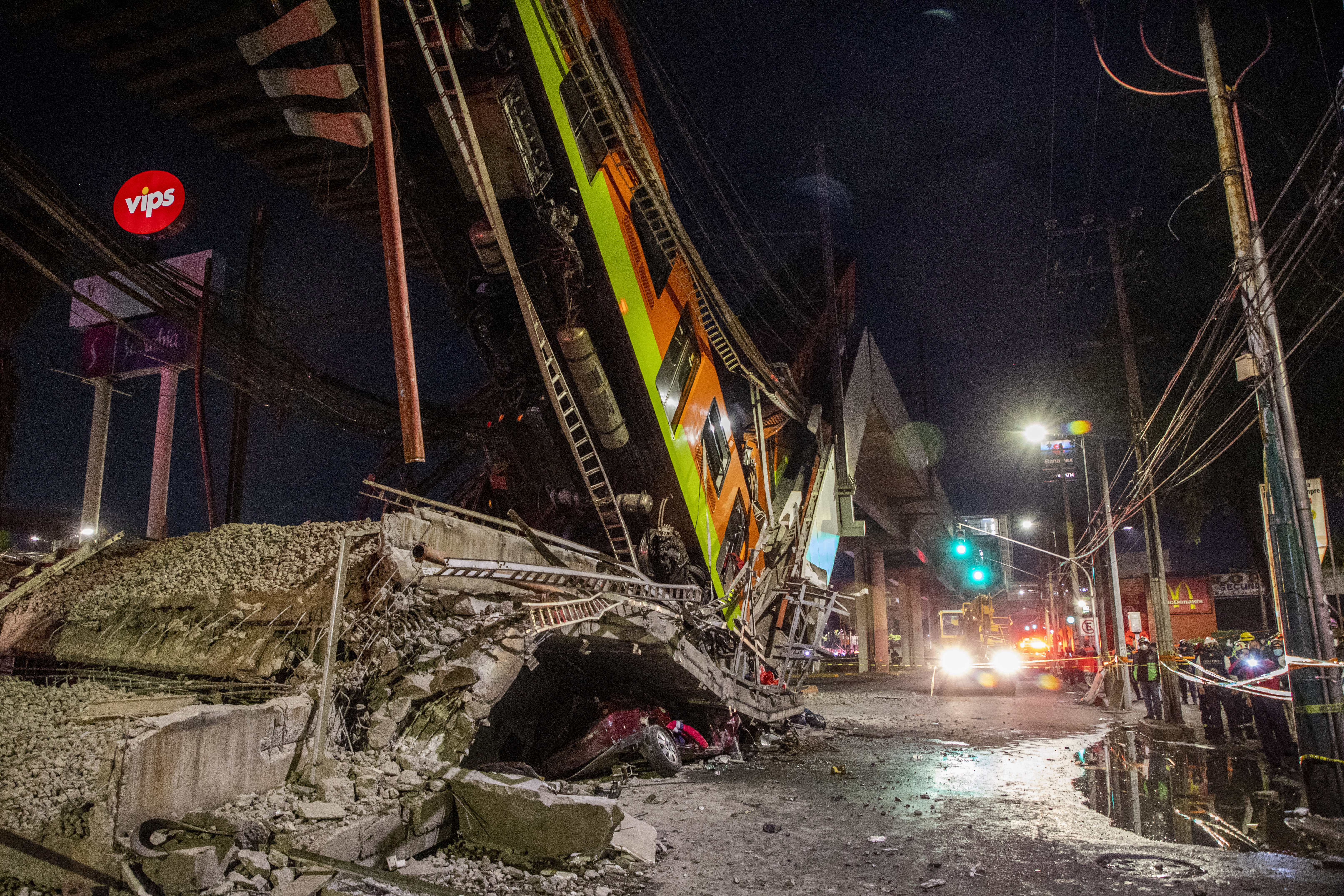 A car lies under debris after a section of a bridge on the 12 subway line collapses in Mexico City.