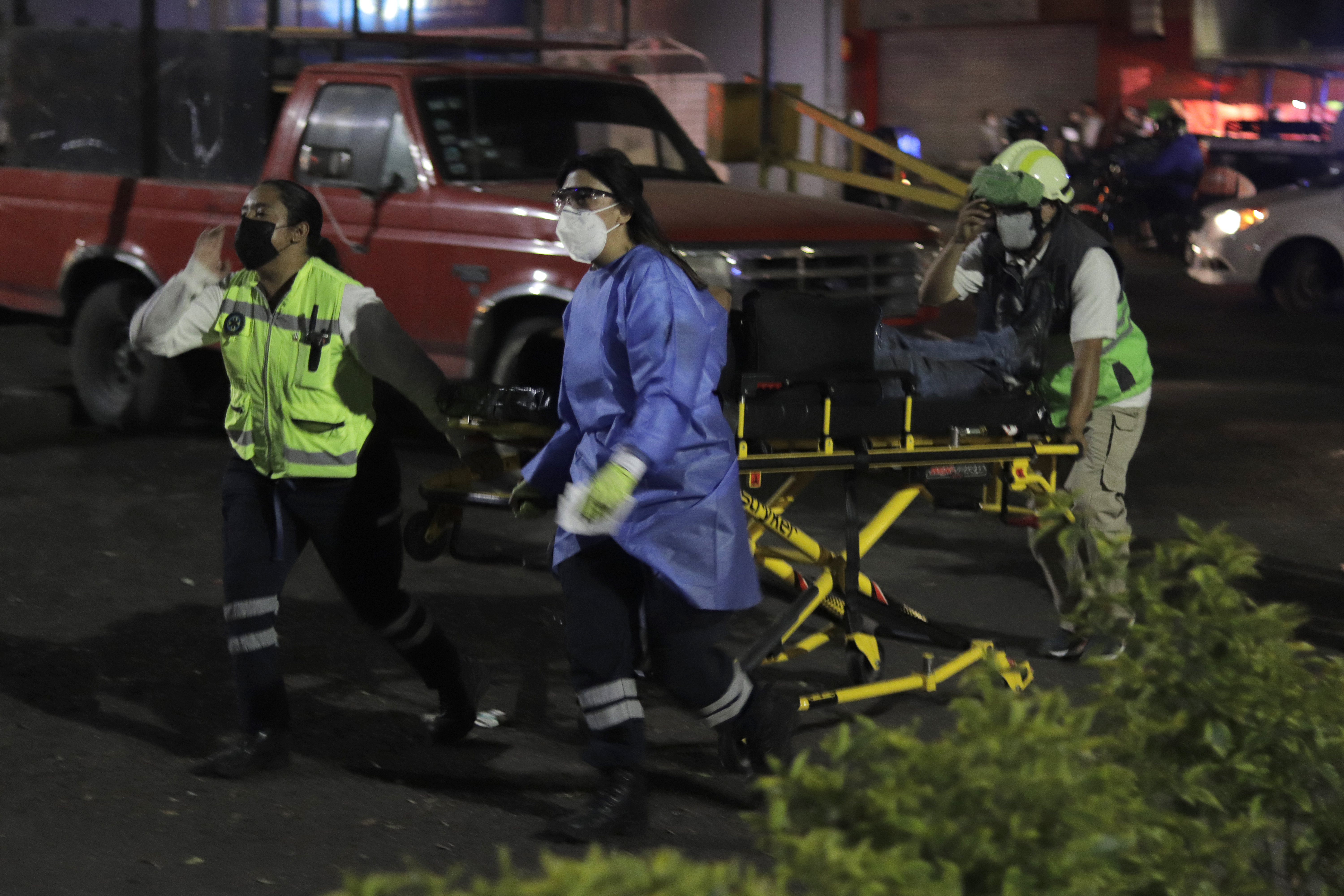 Paramedics transfer an injured person on a stretcher to be taken to a hospital after the collapse of a structure on Line 12 Metro in Mexico City between Tezonco and Olivos stations, where 20 people died and more than 70 were injured. The causes of the accident are still unknown.