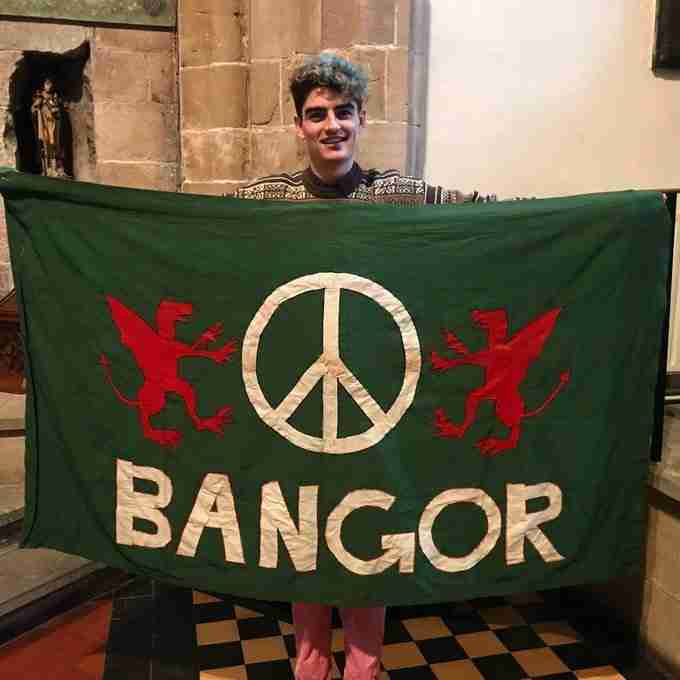 Owen Hurcum carries a green flag with "BANGOR" on it.