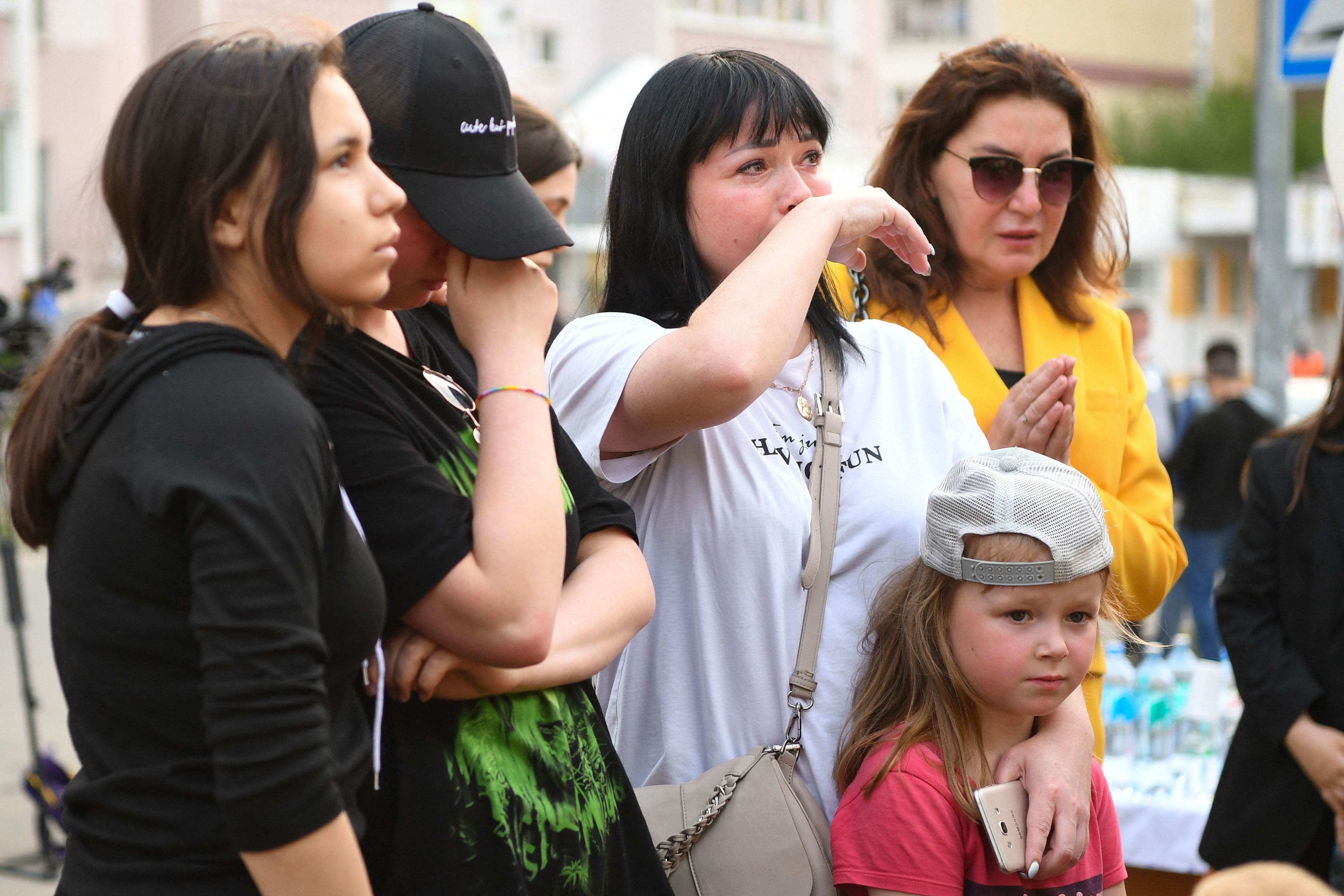 People react at a makeshift memorial for victims of the shooting at School No. 175 in Kazan.