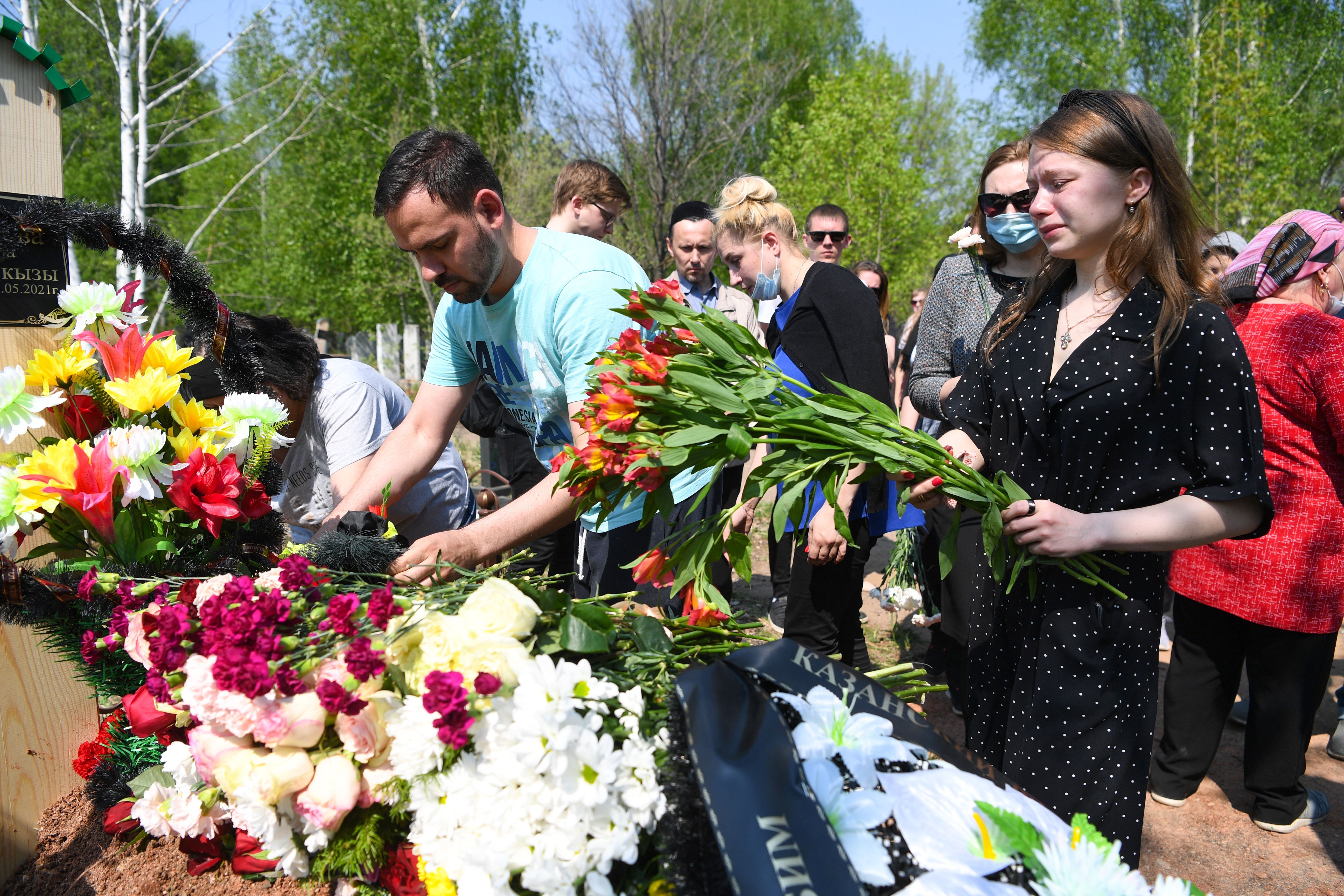Mourners lay flowers at the grave of English teacher Elvira Ignatyeva, who was killed during a shooting at School No. 175, during her funeral in Kazan.