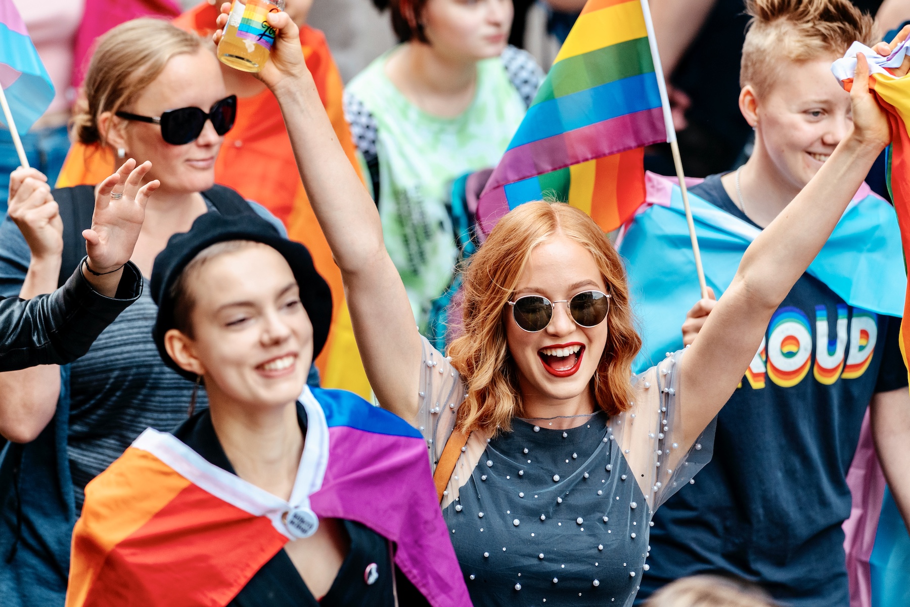 people smiling and celebrating at a pride parade