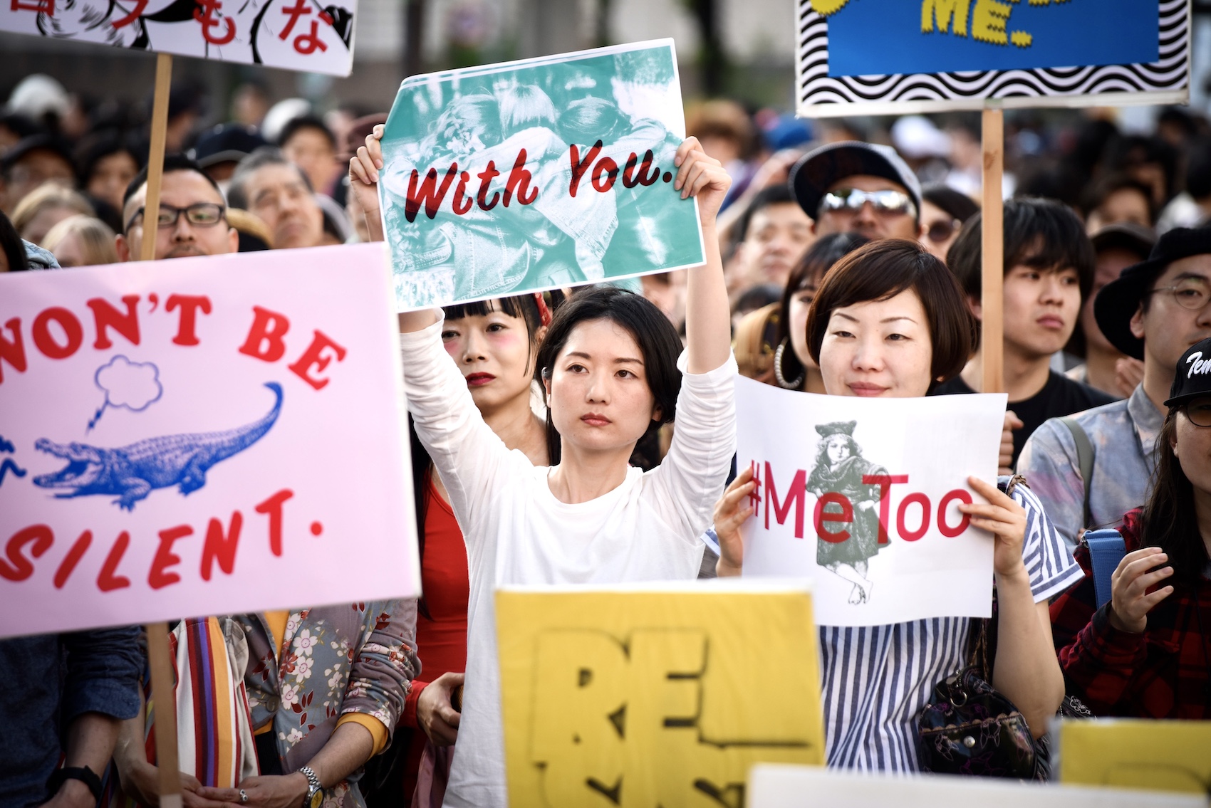 Demonstrators hold signs during a rally against sexual harassment in Shinjuku, Tokyo