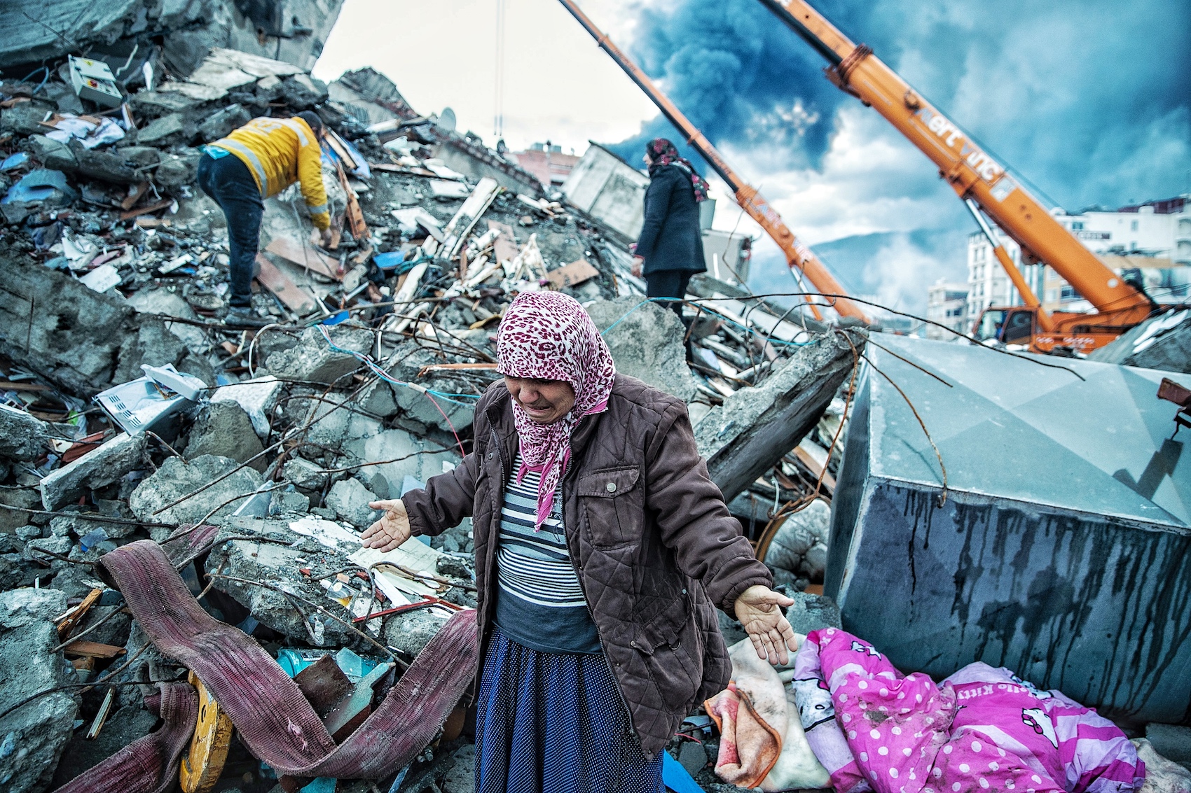 an old lady stretching out her arms standing on the collapsed buildings looking down