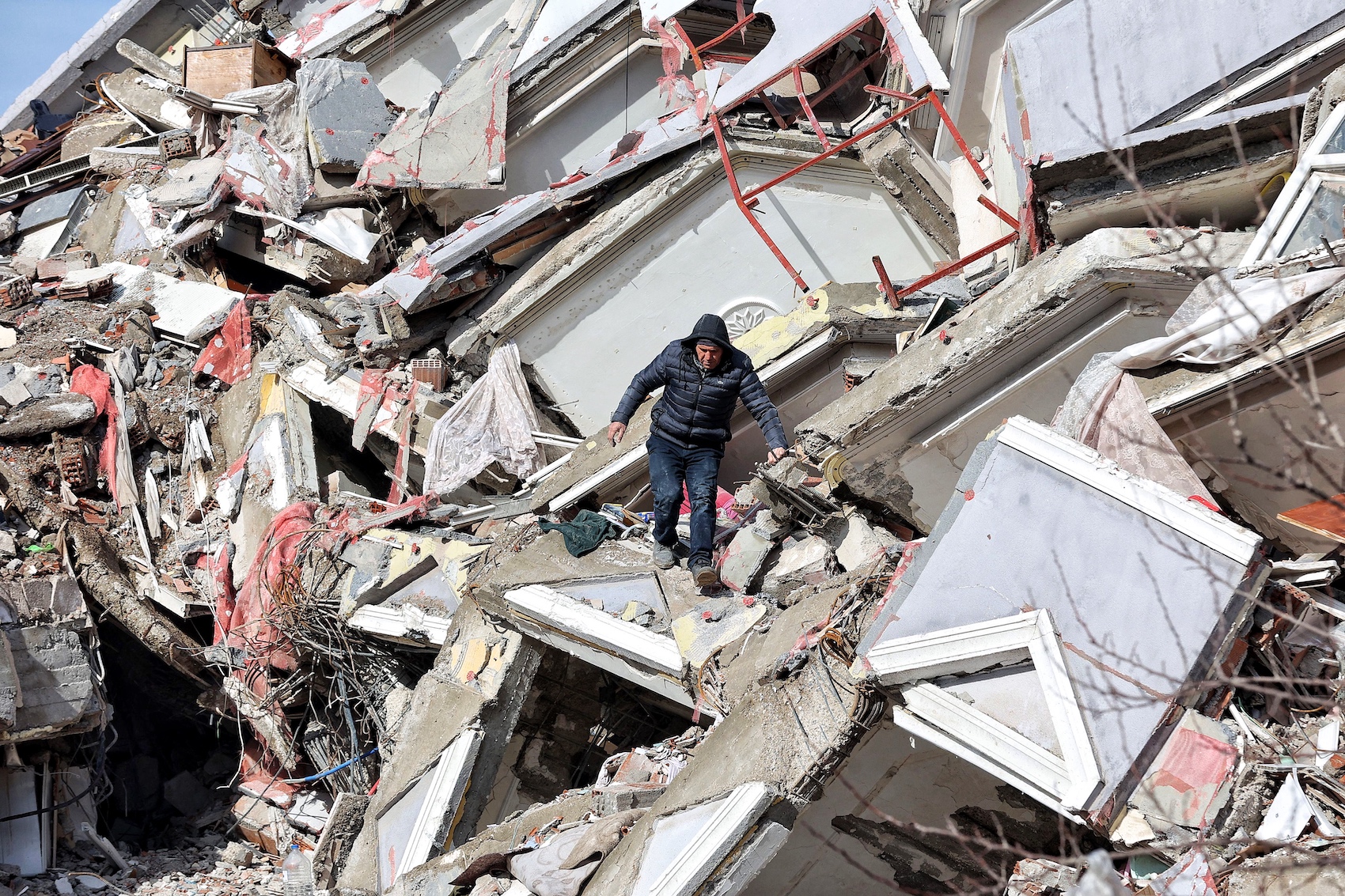 a man standing in the middle of the collapsed buildings