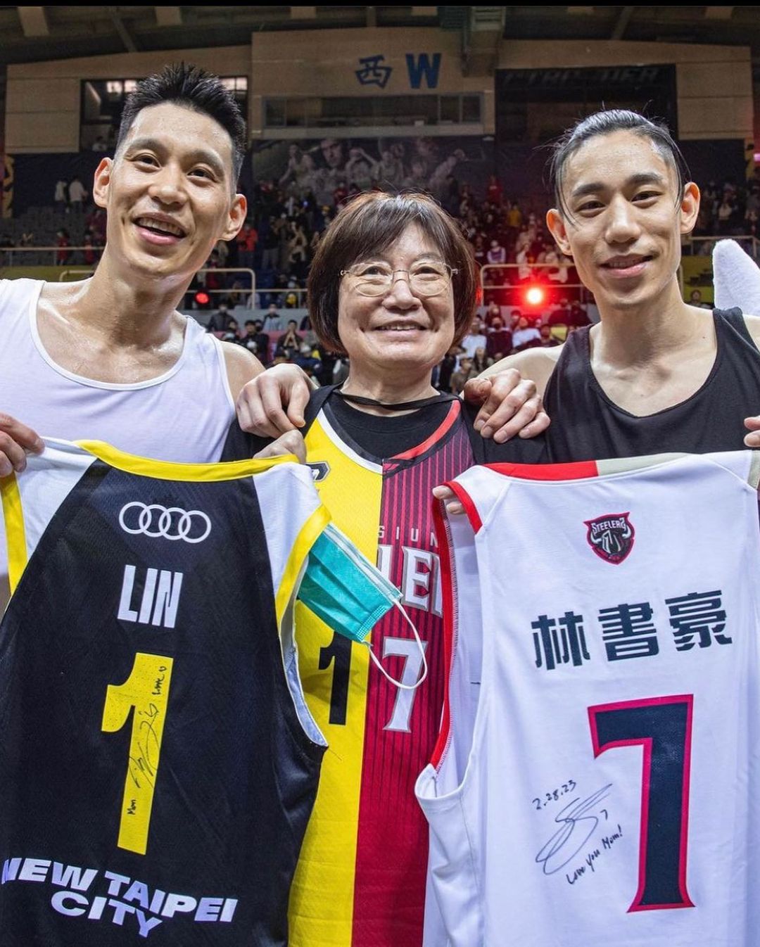 a group picture of jeremy lin and joseph lin and their mom holding their basketball team shirt