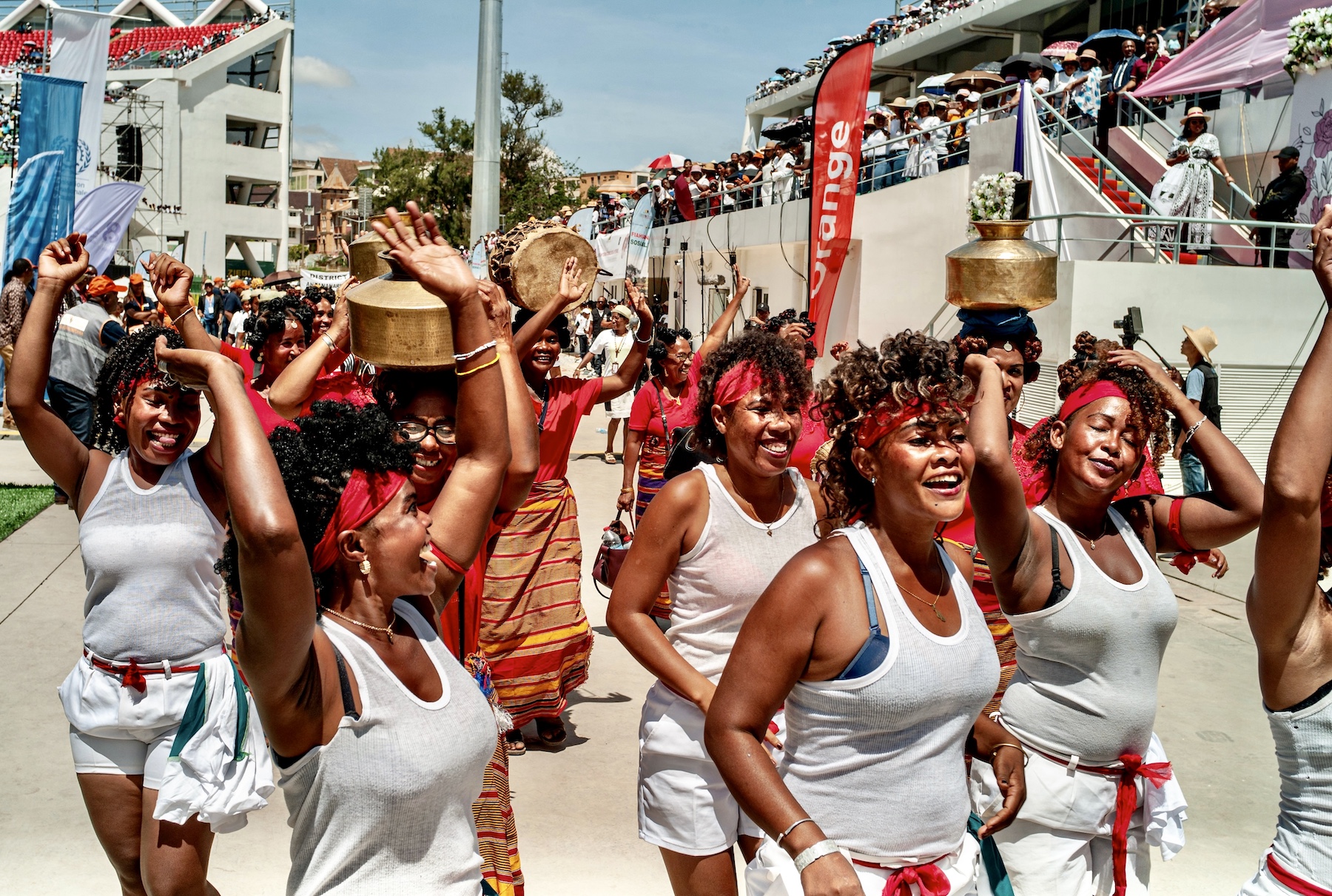 On International Women's Day in Madagascar, women march in a parade while sporting red and white headbands.
