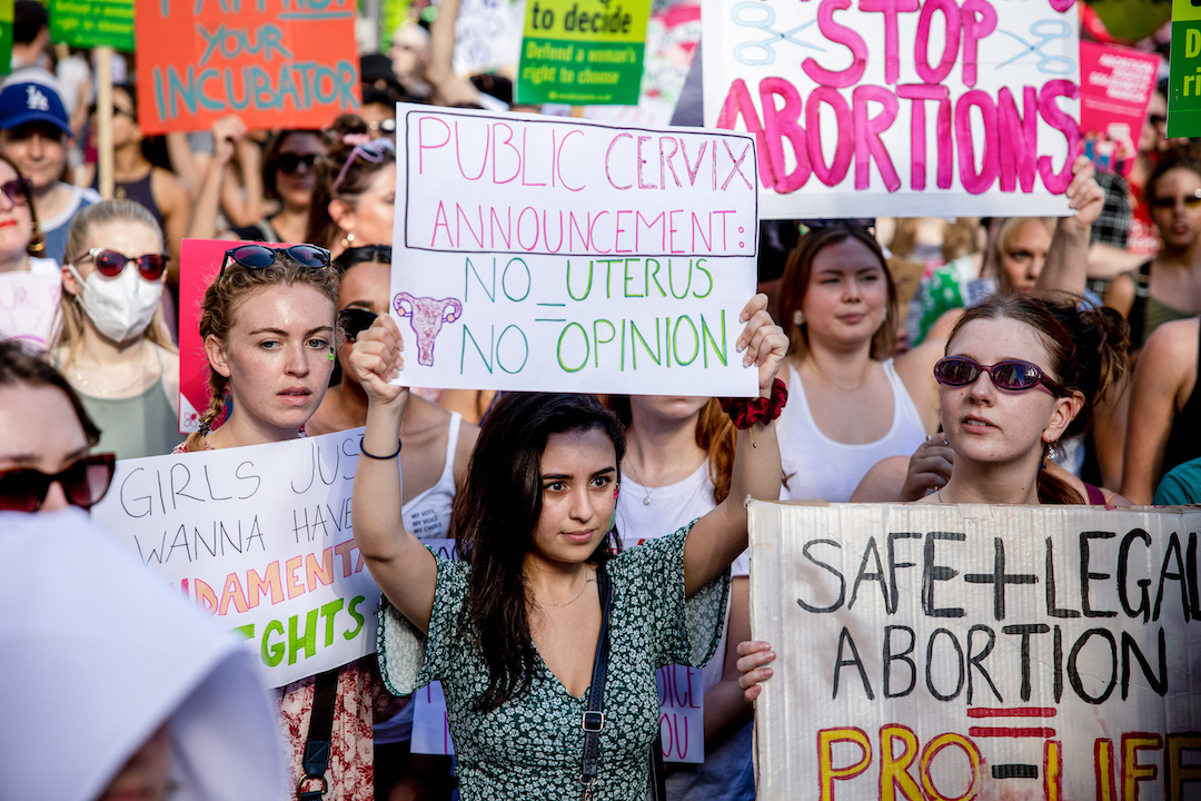 Protesters hold placard signs about pro-abortion 