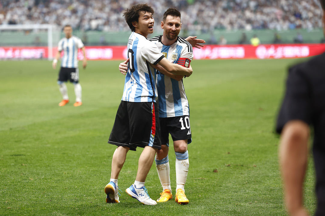 A Chinese fan hugs Messi during Argentina v Australia friendly match in China