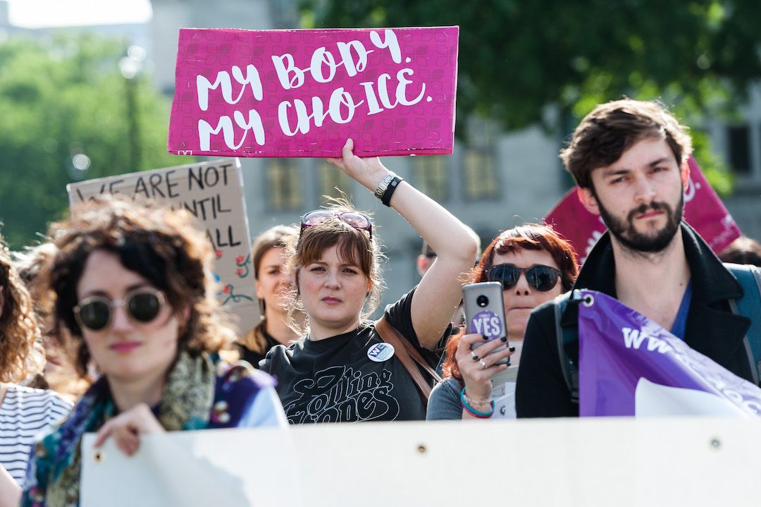 UK woman holds sign that reads, "My body. My choice".