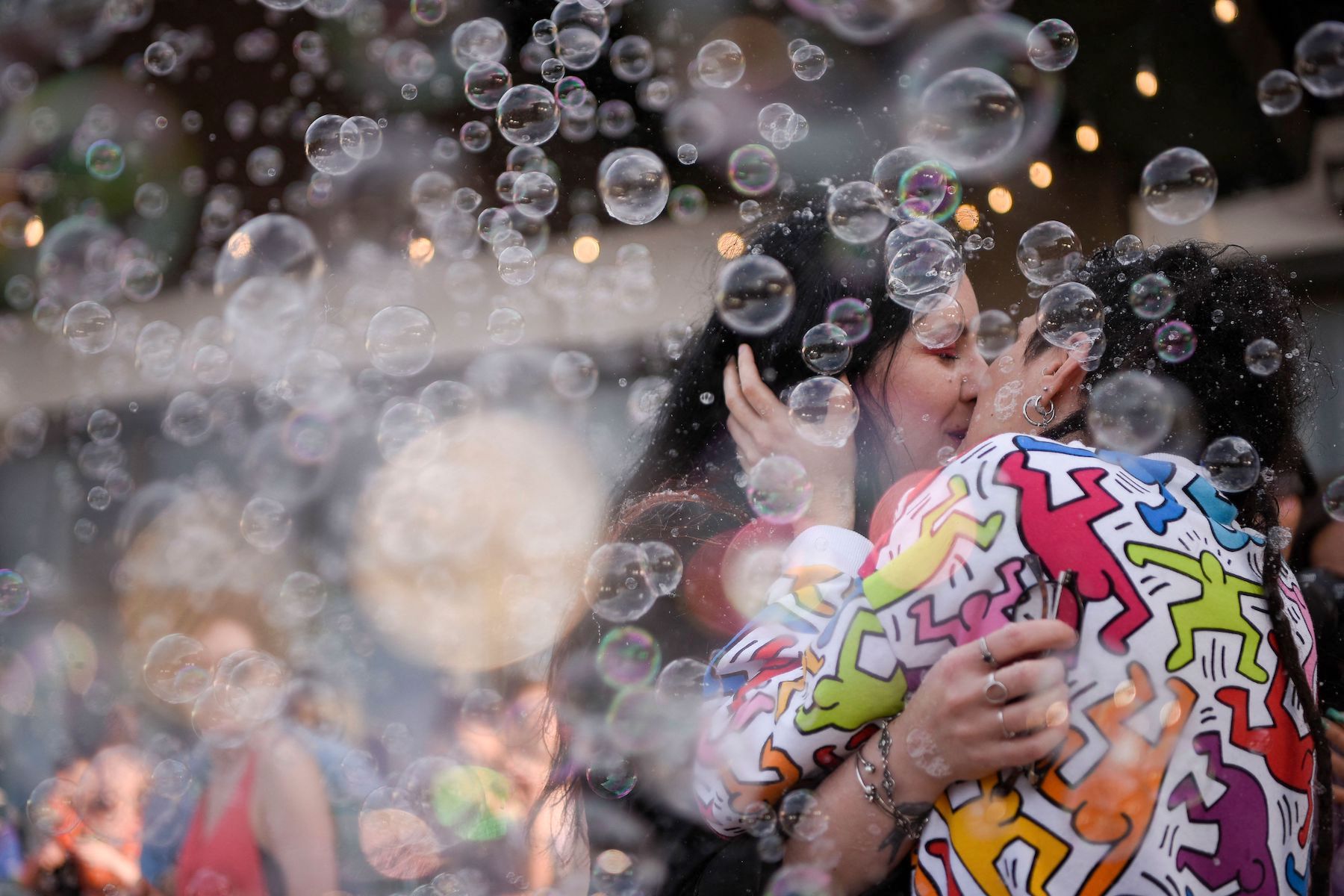 A lesbian couple kisses under soap bubbles during Kosovo's pride march.