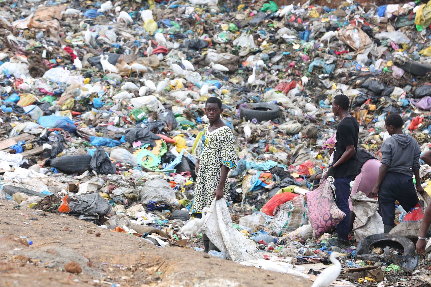Young men search through trash gabon