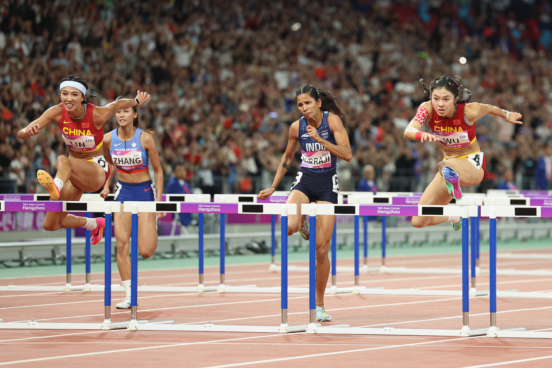 LinYuwei (L) of China, Wu Yanni (R) compete in the women's 100m hurdles at the Asian games at Hangzhou, China.