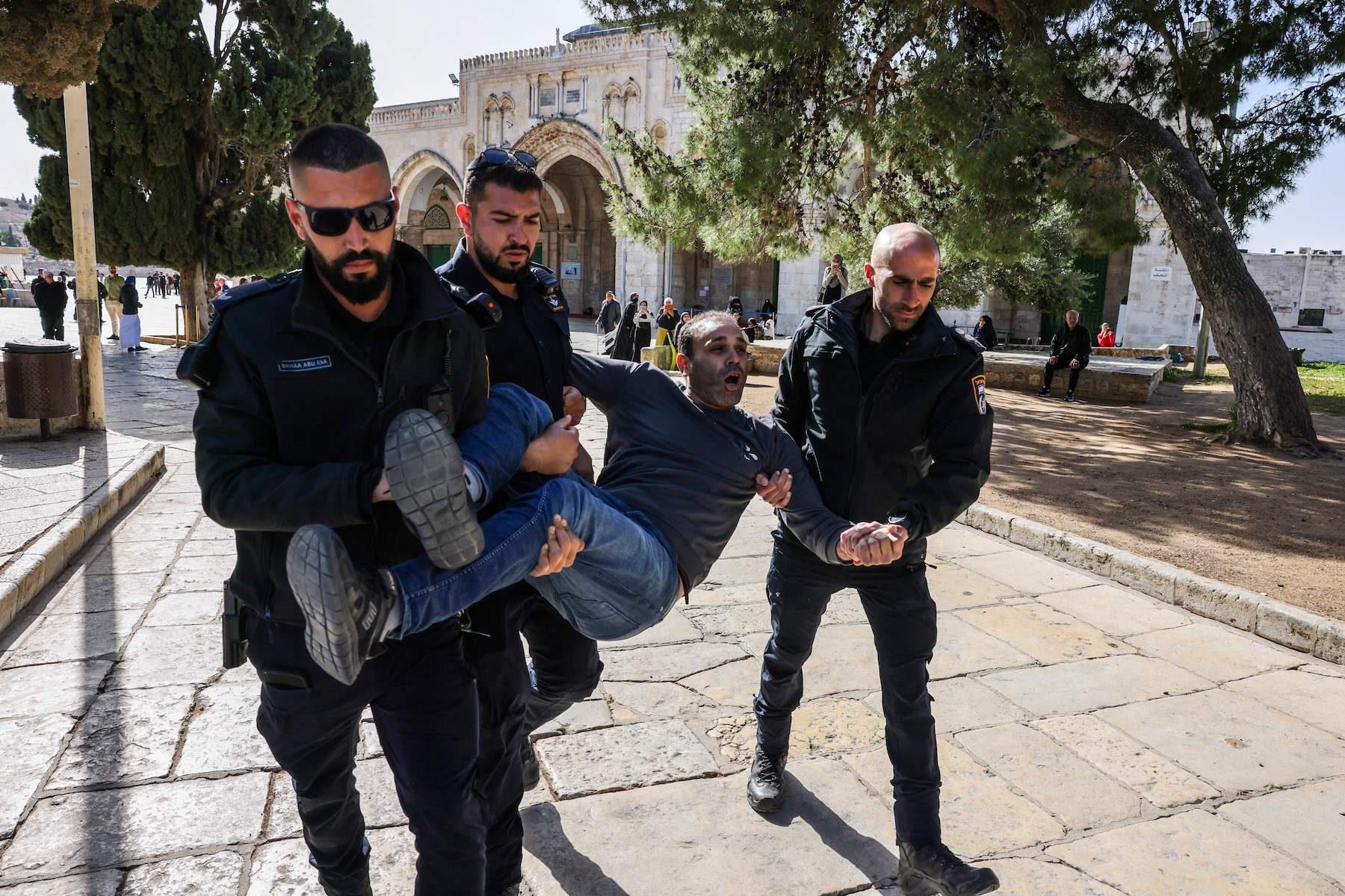 Israeli policemen detain a Palestinian man