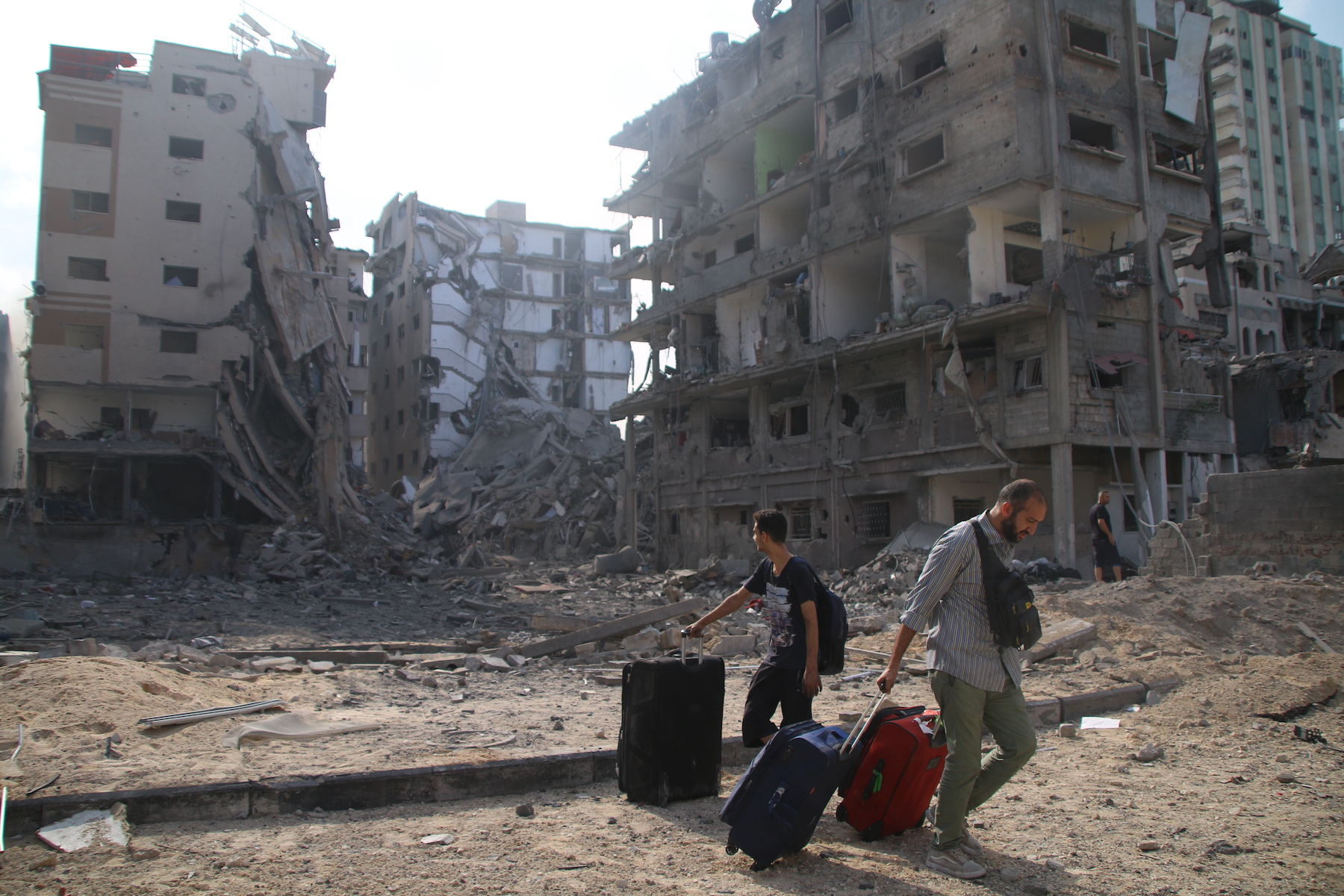 Palestinian citizens evacuate their homes damaged by Israeli airstrikes