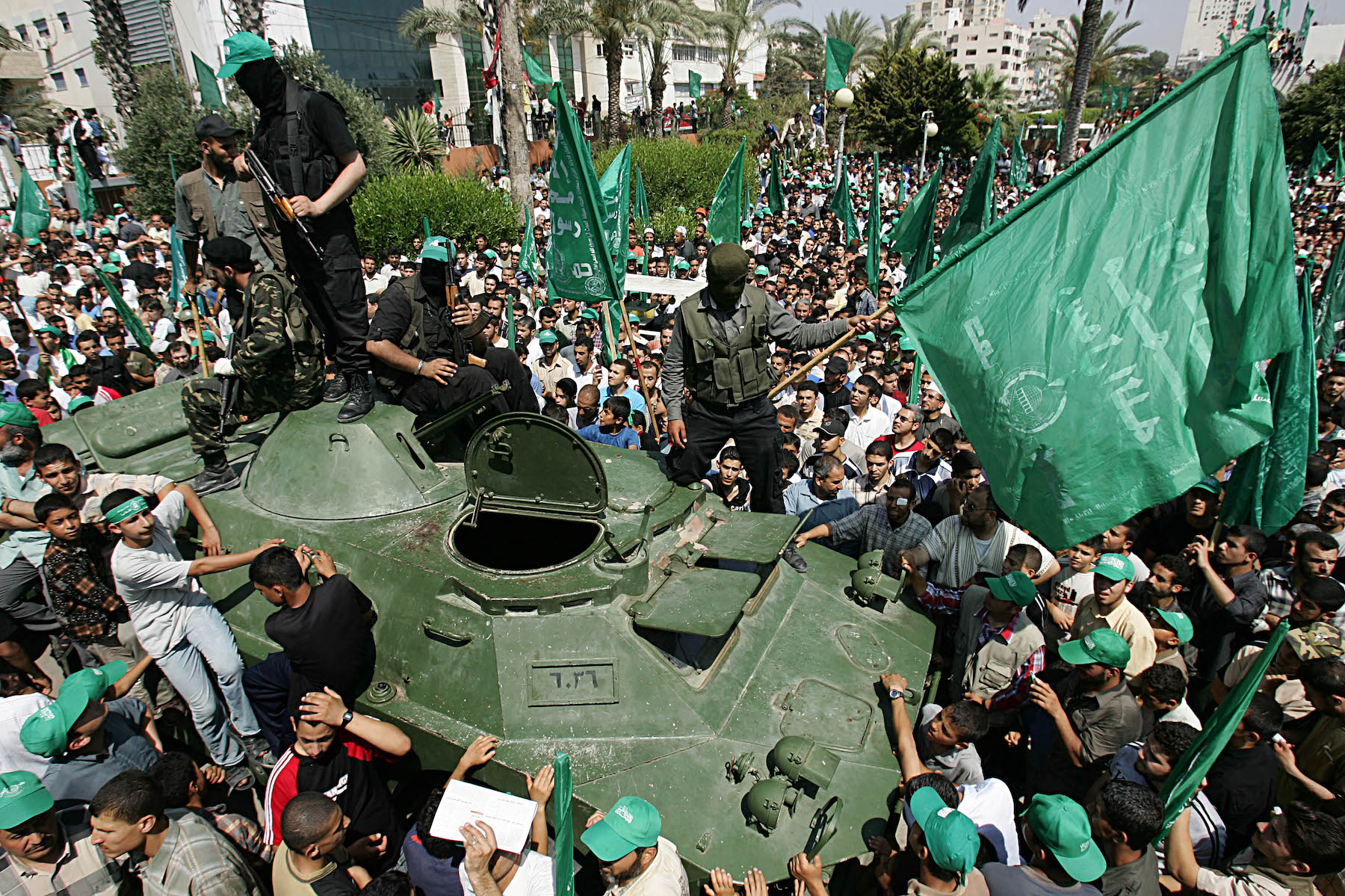 Palestinian Hamas members ride an armored vehicle
