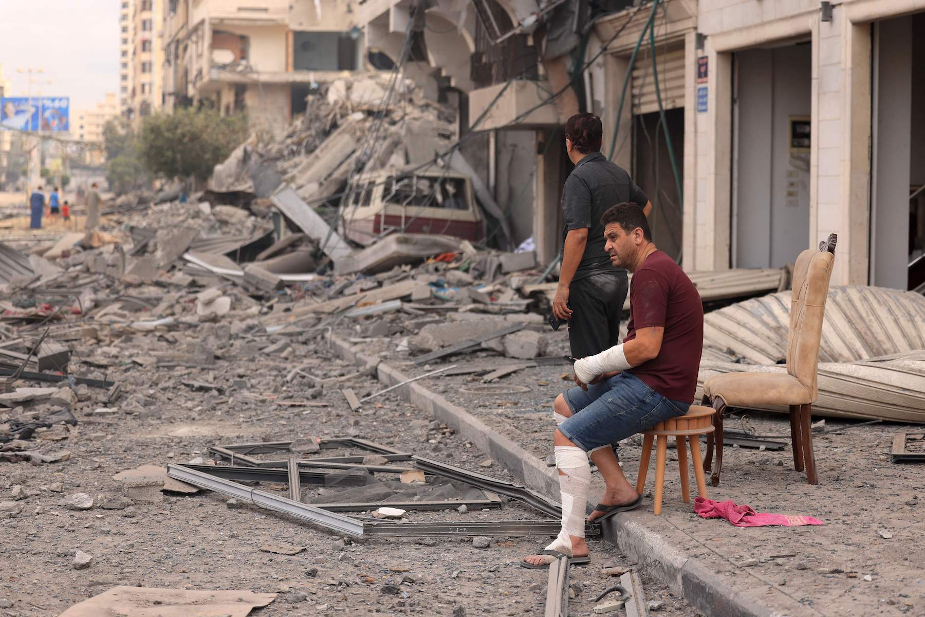 Palestinian men look at the destruction outside a damaged apartment building