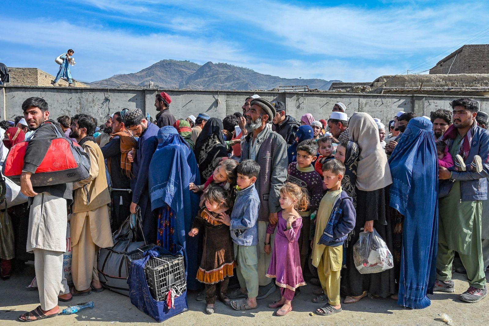 Afghan refugees wait in a queue to cross the Pakistan Afghanistan border
