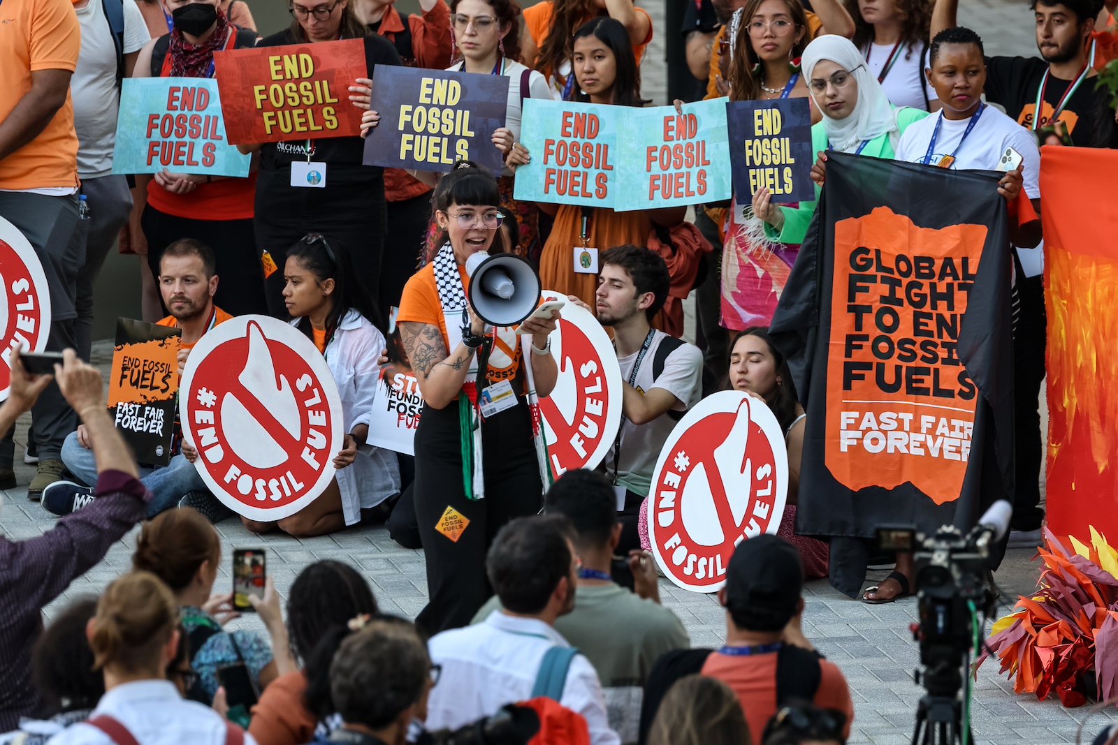 Participants stage a protest calling to phase out fossil fuels during the COP2