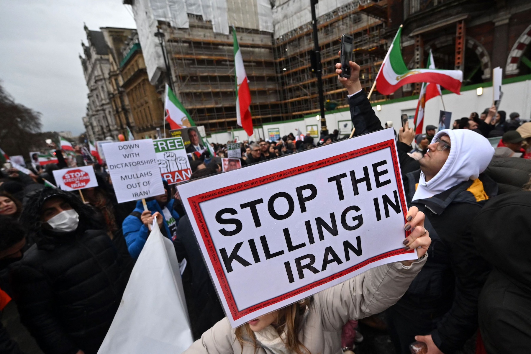 Protesters hold placards iran against the Iranian regime
