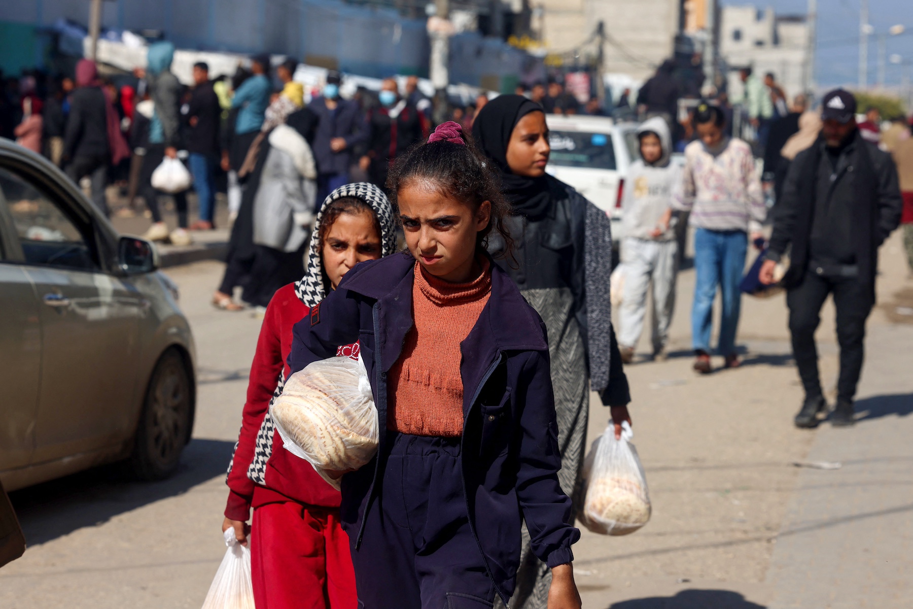Palestinian girls carry fresh bread in Rafah gaza