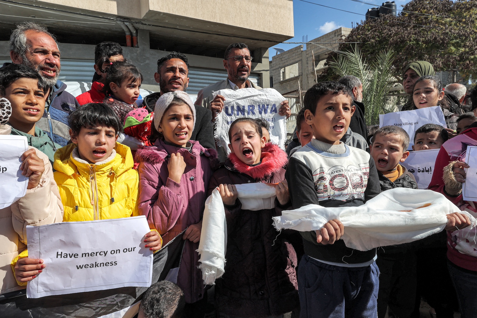 Palestinian men and children gather for a demonstration in Rafah UNRWA