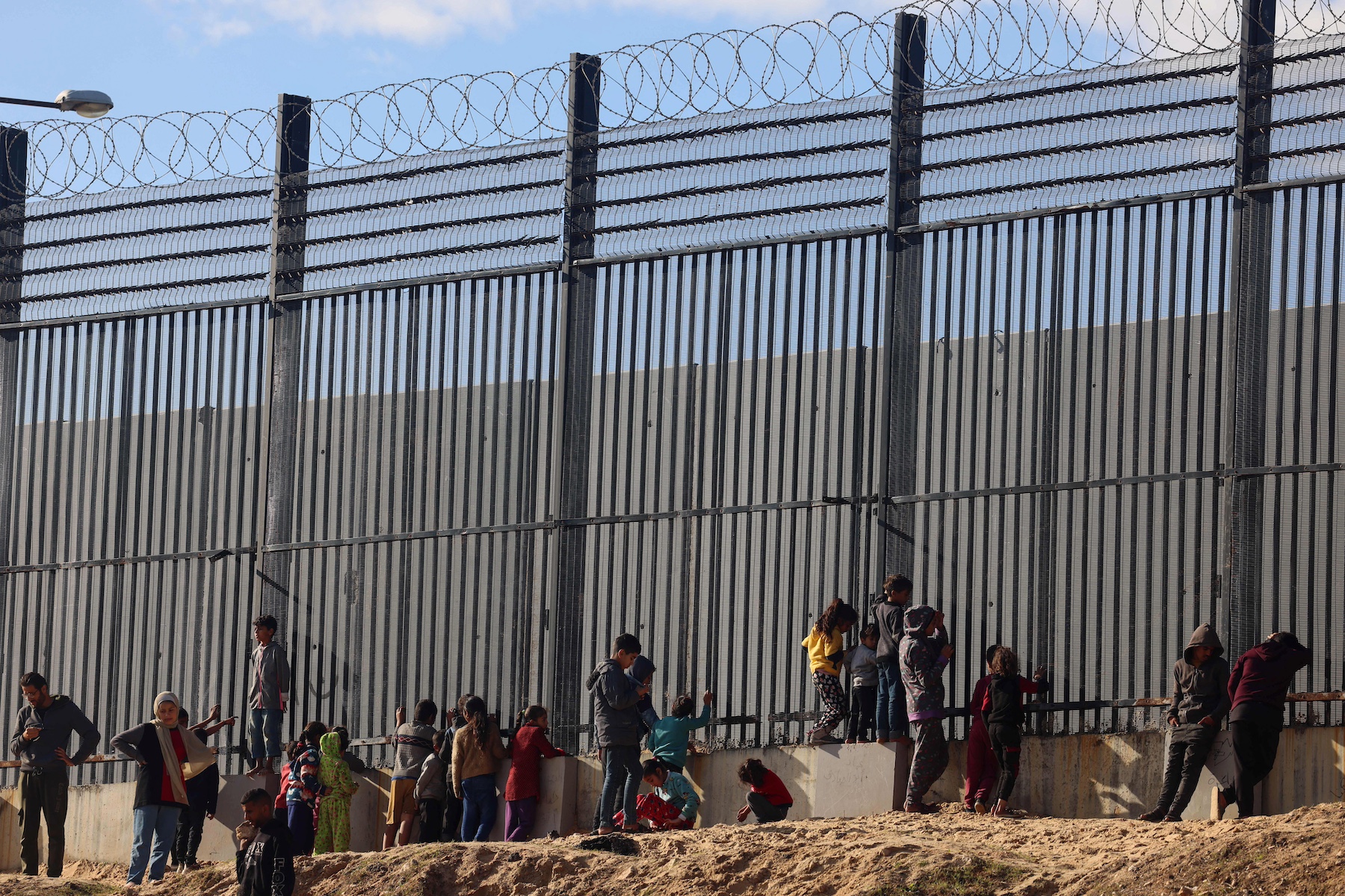 Palestinians stand border fence Egypt rafah gaza